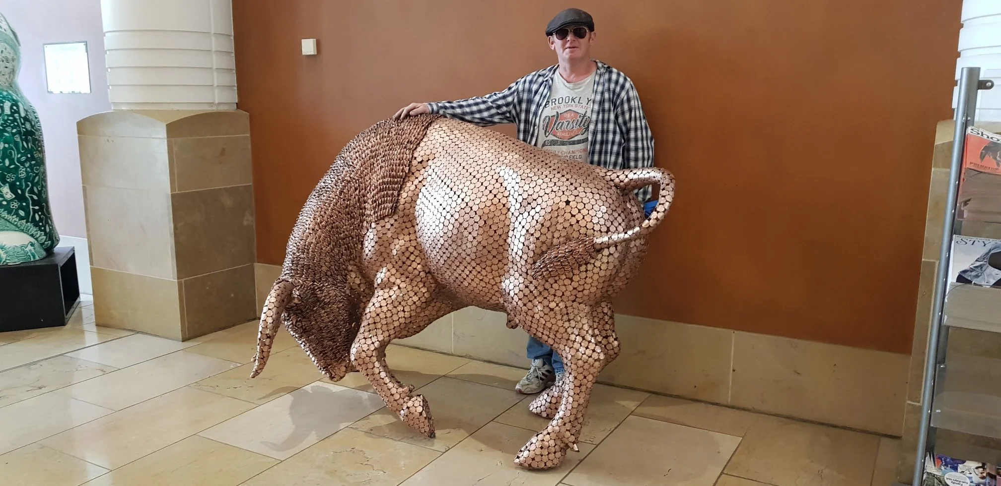 Shaun Gagg's sculpture shows a bull in a charging stance, head lowered and horns forward. Made of tightly arranged two pence coins, it captures strength and motion.