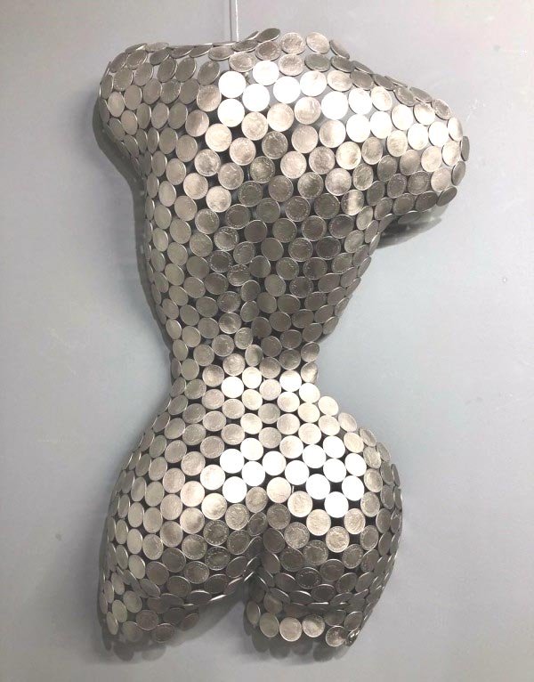 A 10P Torso Rear" by Shaun Gagg, a life-size sculpture crafted from 10p coins. It can be displayed on a base or hung on a wall, offering versatility in showcasing the detailed artistry of the piece.