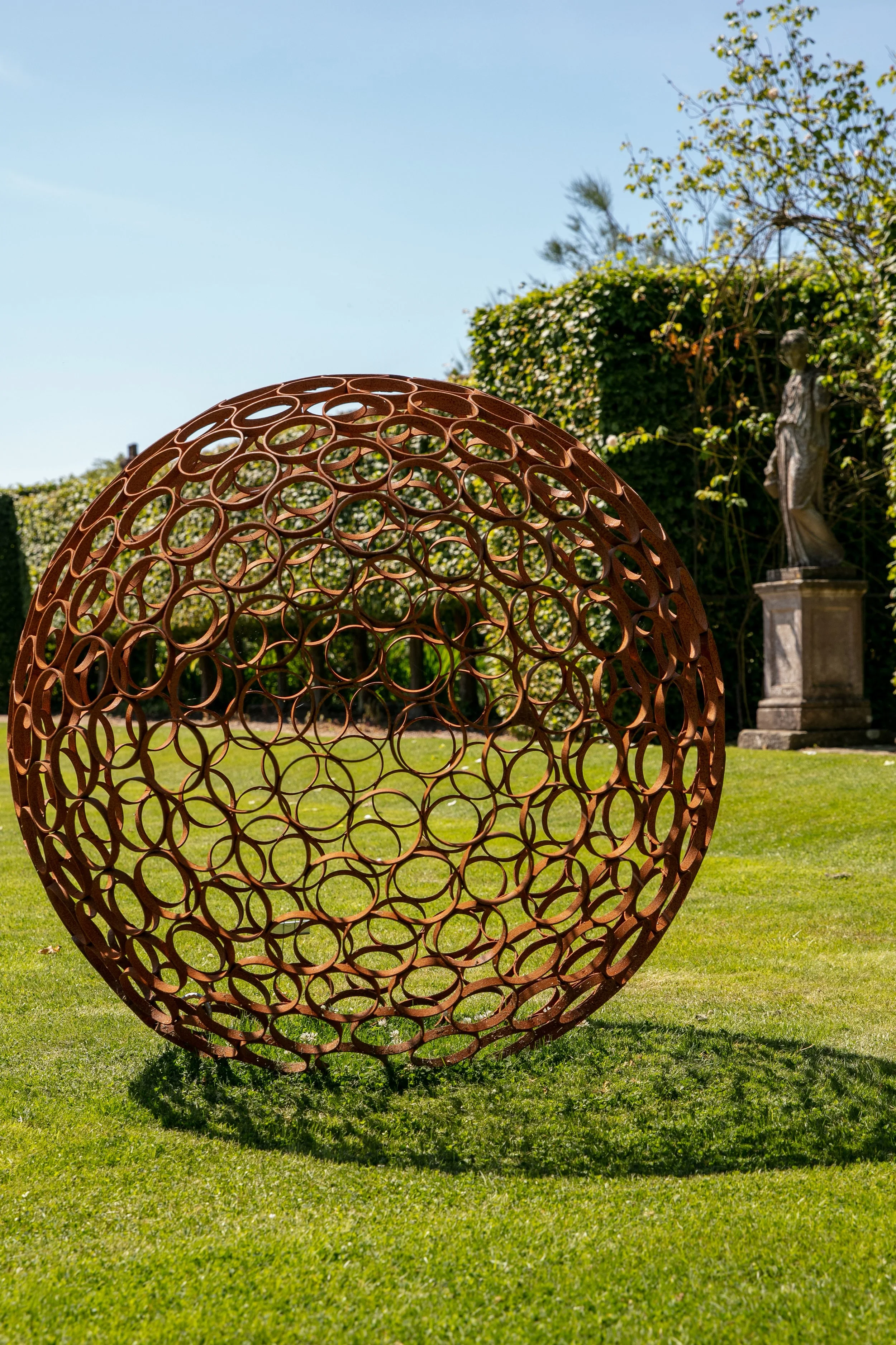 This sculpture is a sphere. Crafted by cutting steel pipes into slices and welding them together from the inside.  Note: The sphere will eventually rust over time.