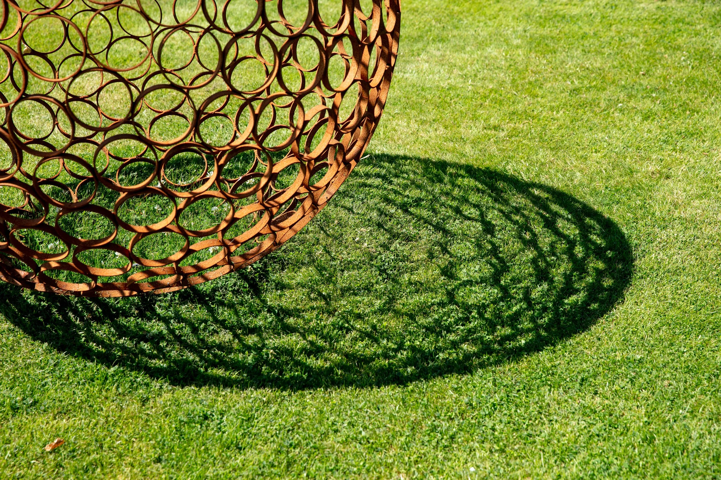 This sculpture is a sphere. Crafted by cutting steel pipes into slices and welding them together from the inside.  Note: The sphere will eventually rust over time.
