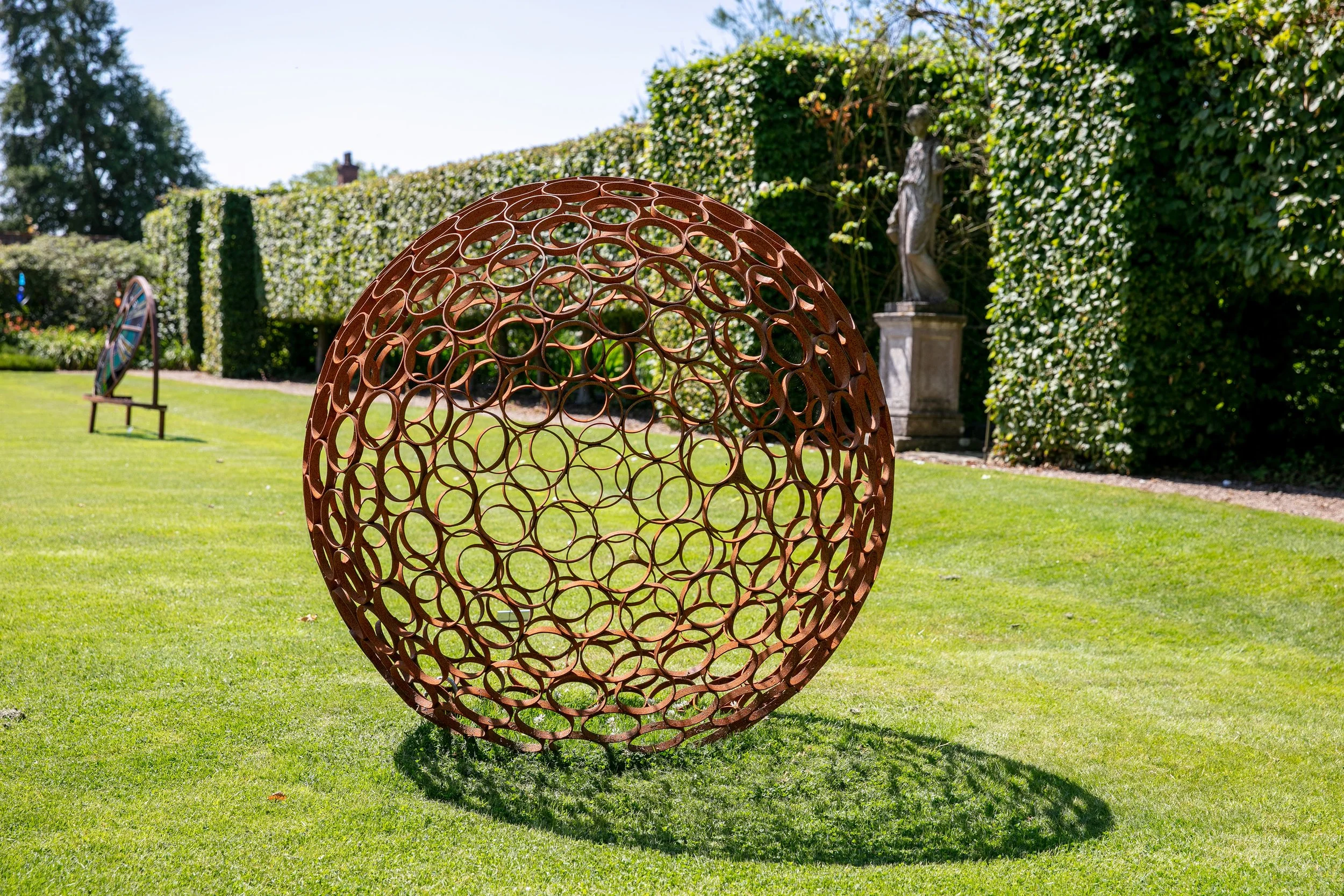 This sculpture is a sphere. Crafted by cutting steel pipes into slices and welding them together from the inside.  Note: The sphere will eventually rust over time.