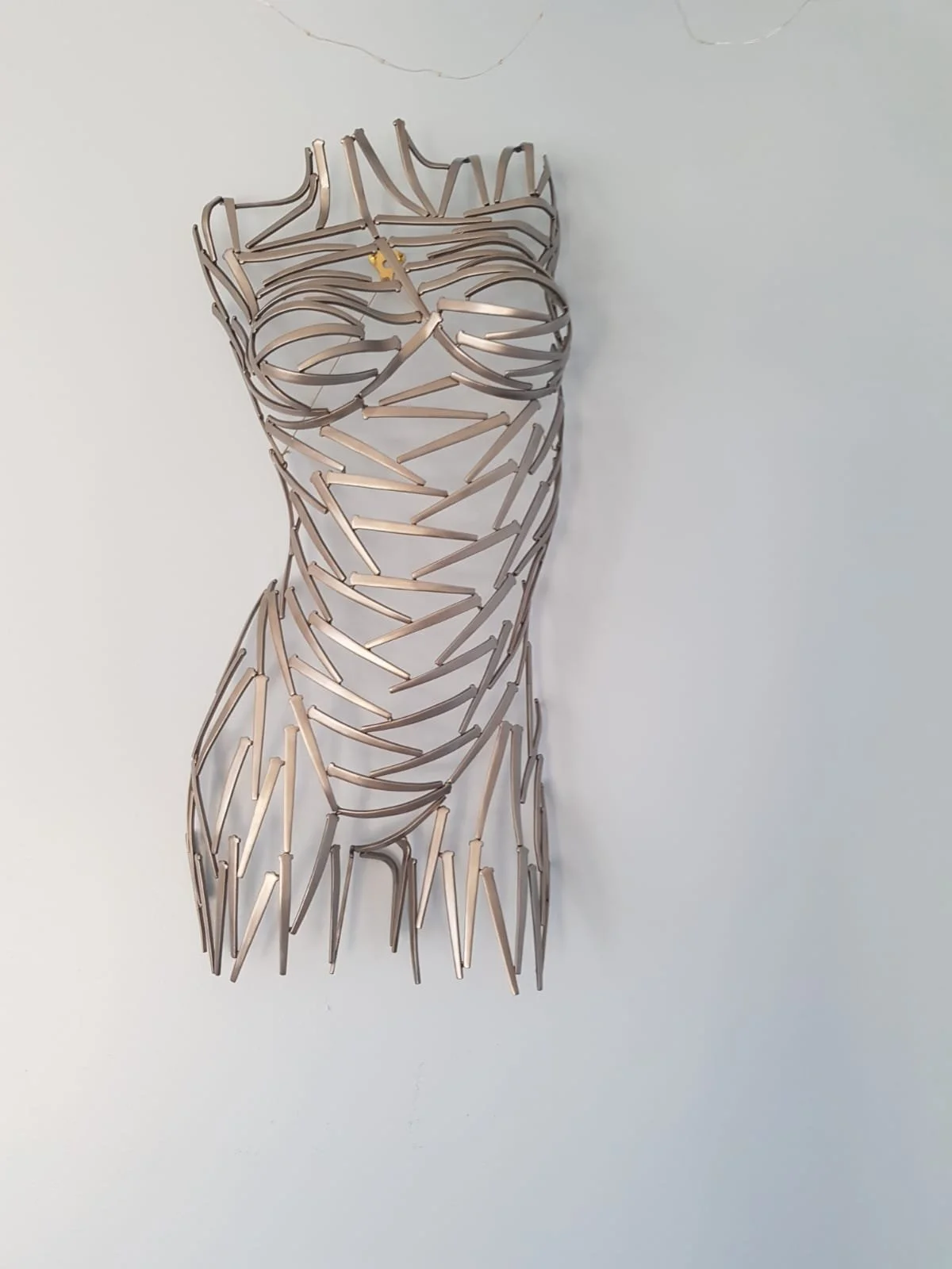 A torso sculpted from nails—sharp, textured, and raw. Suspended or grounded, it plays with light and shadow, turning metal into movement.