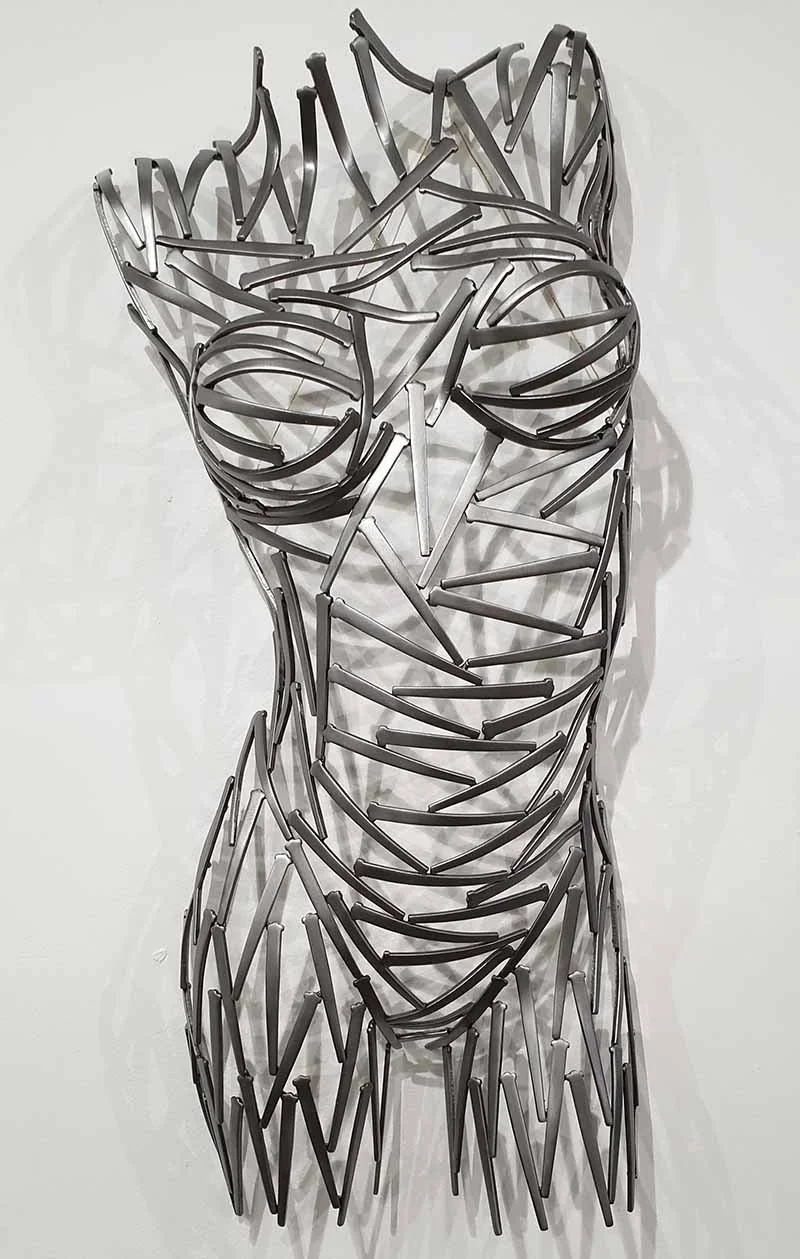 A torso sculpted from nails—sharp, textured, and raw. Suspended or grounded, it plays with light and shadow, turning metal into movement.