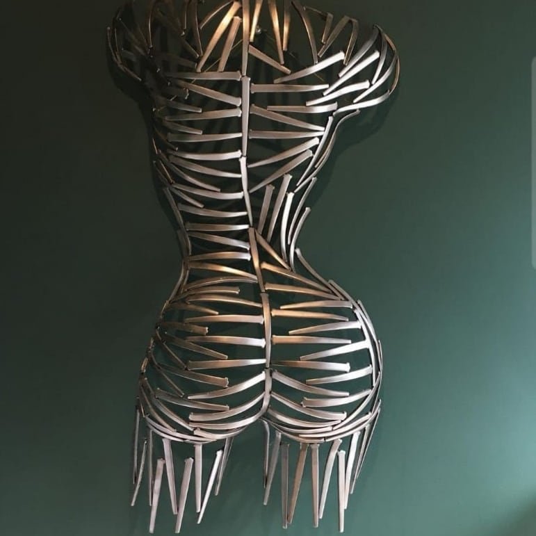 A torso sculpted from nails—sharp, textured, and raw. Suspended or grounded, it plays with light and shadow, turning metal into movement.
