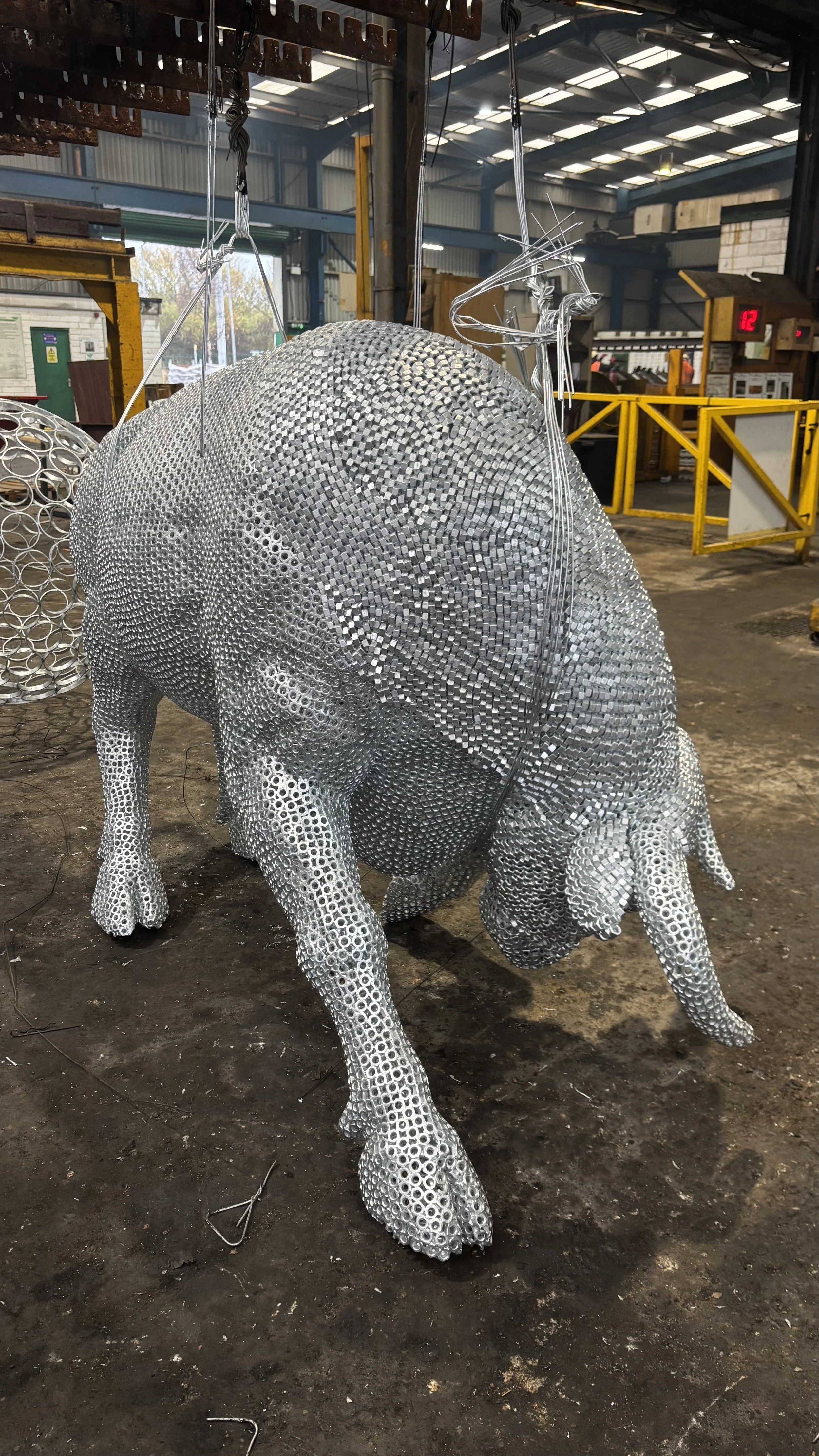 “A detailed bull sculpture by Shaun Gagg, built from 14,000 metal nuts and over 50,000 welds, giving it a strong, textured, industrial appearance.”