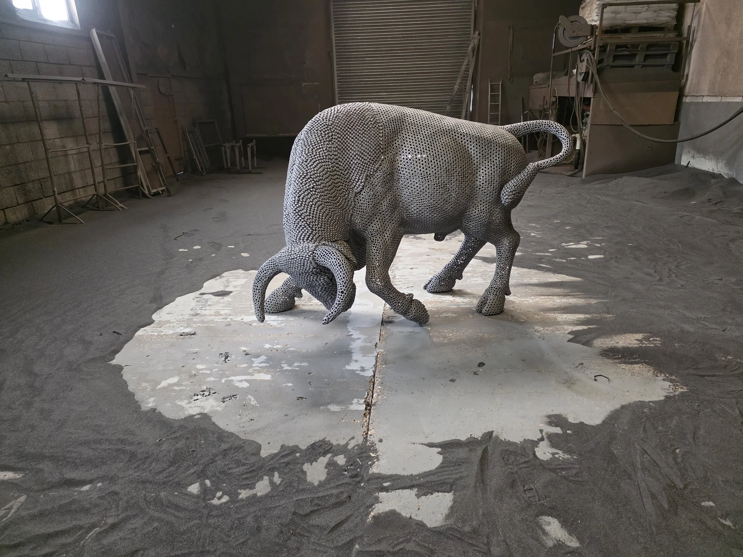 “A detailed bull sculpture by Shaun Gagg, built from 14,000 metal nuts and over 50,000 welds, giving it a strong, textured, industrial appearance.”