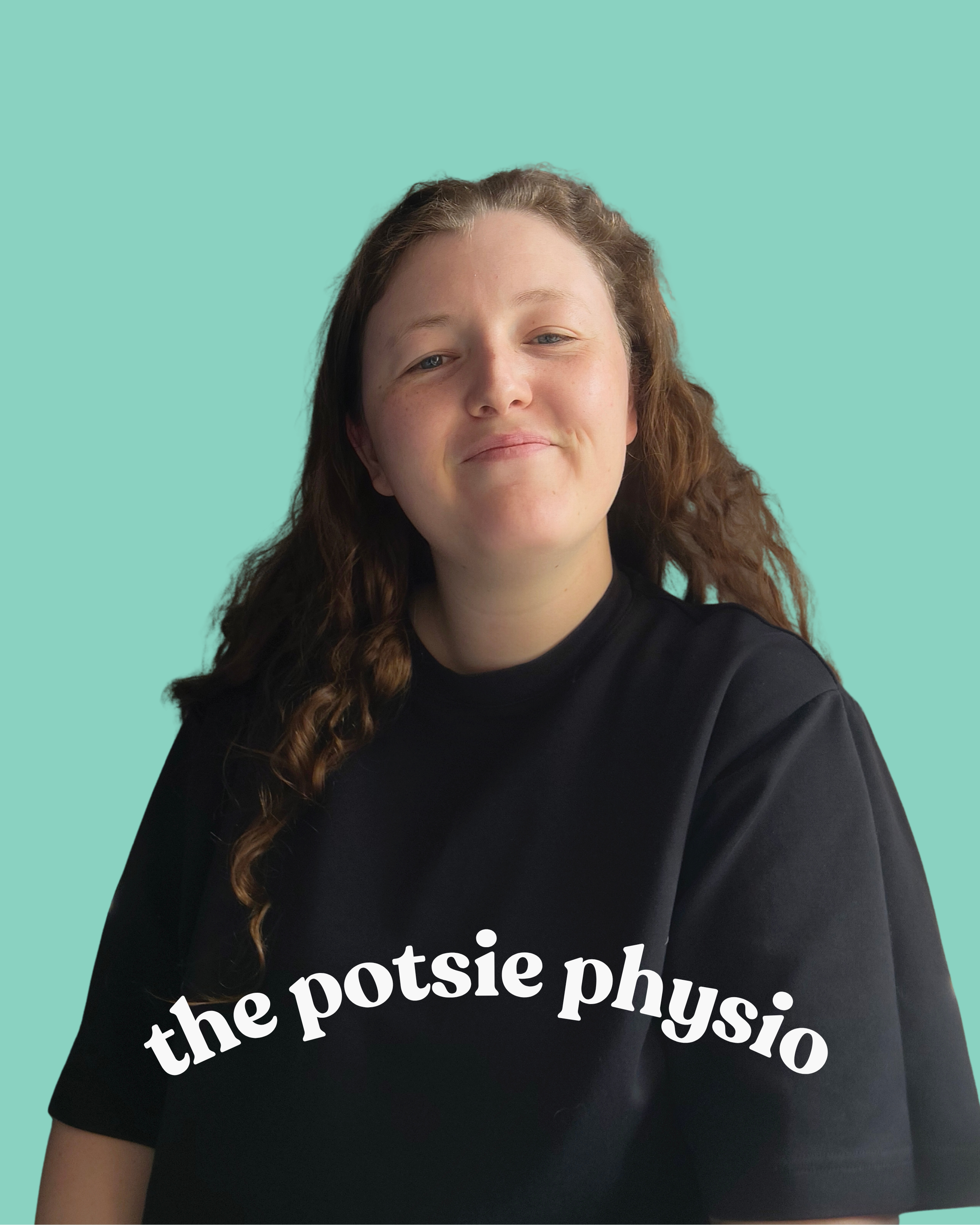 Close-up of a person with long, wavy brown hair wearing a black shirt with white text, against a plain teal background.