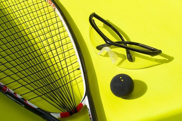 Tennis racket, pair of sunglasses, tennis ball, and a yellow background.
