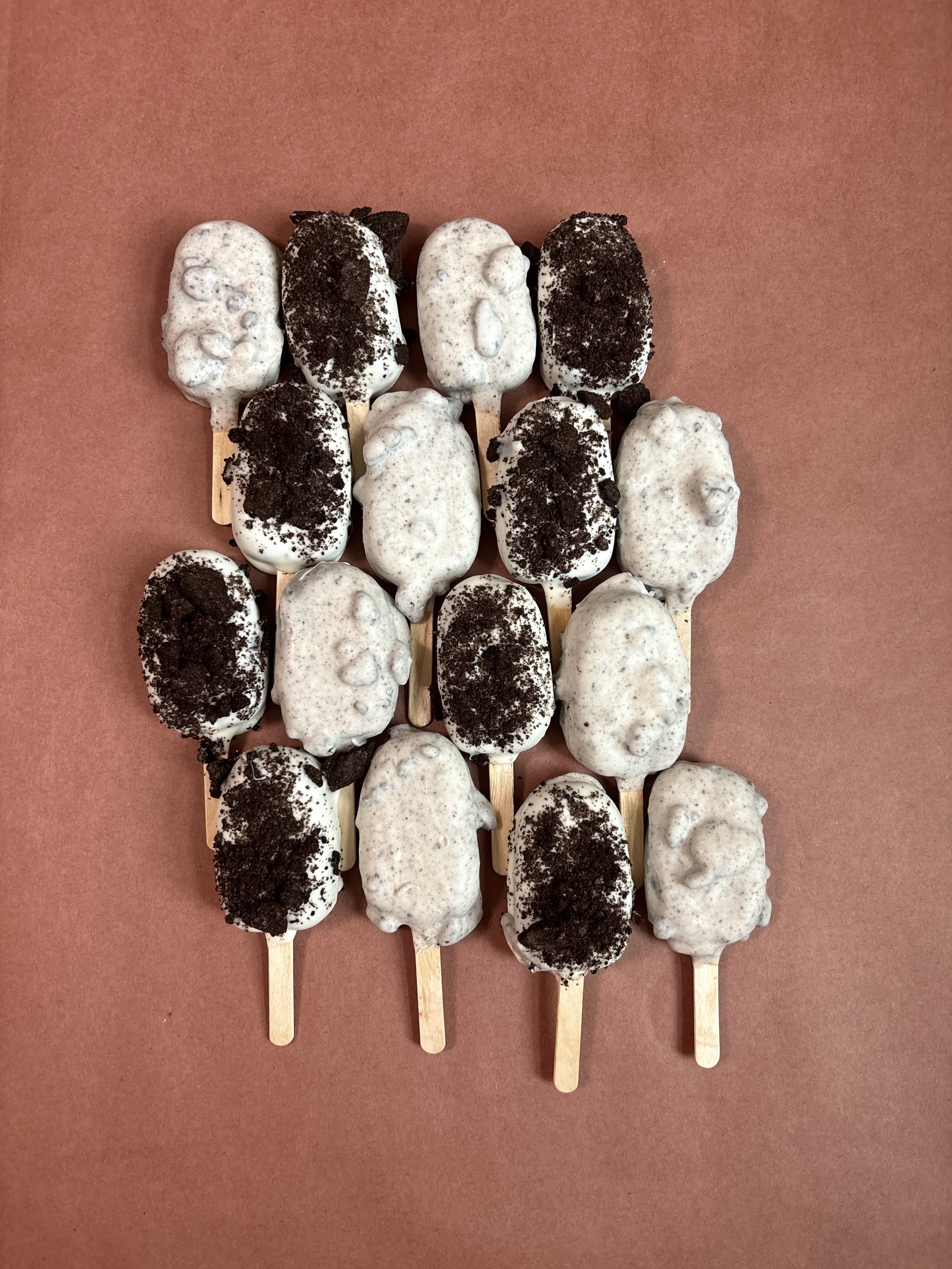 Cookies and cream. A delicious chocolate cake with a cookies and cream coating or vanilla flavored candy coating topped with Oreo cookie crumbles.