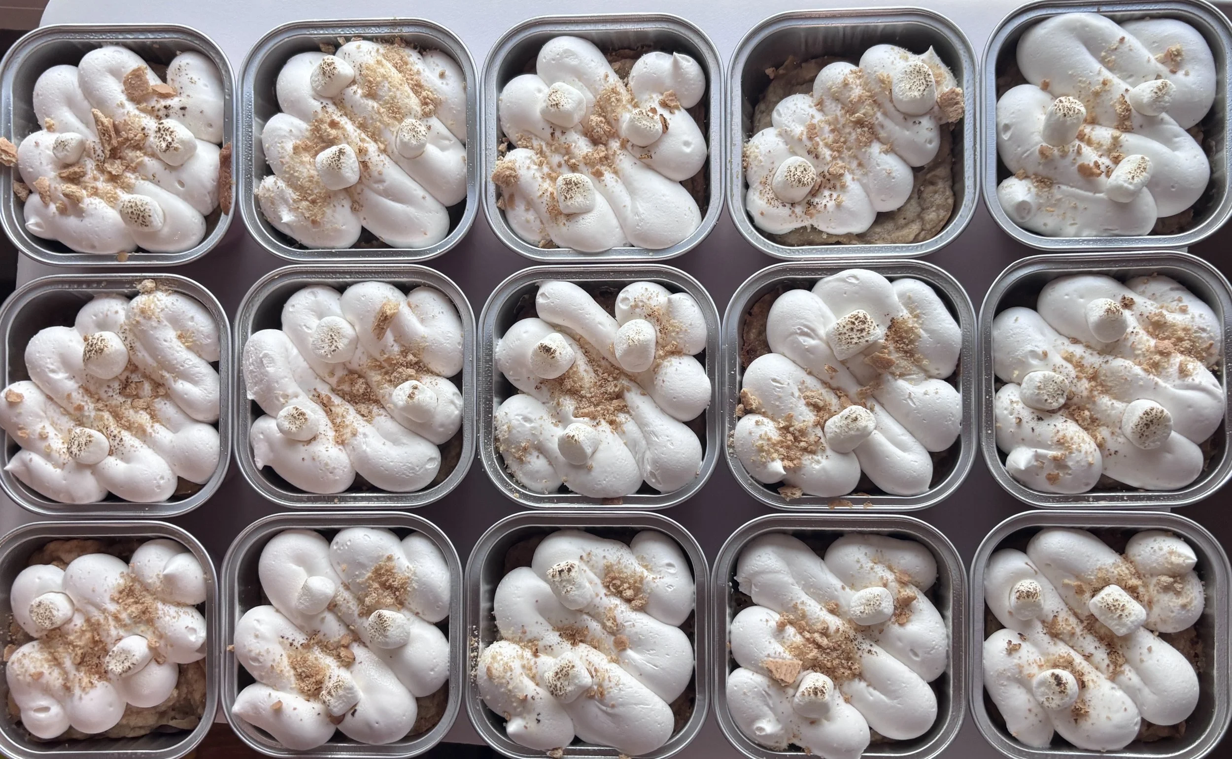 Our s’mores cookie that has chocolate chips, graham crackers and marshmallows in the cookie, topped with a marshmallow buttercream, graham crackers crumbles, and toasted marshmallows.