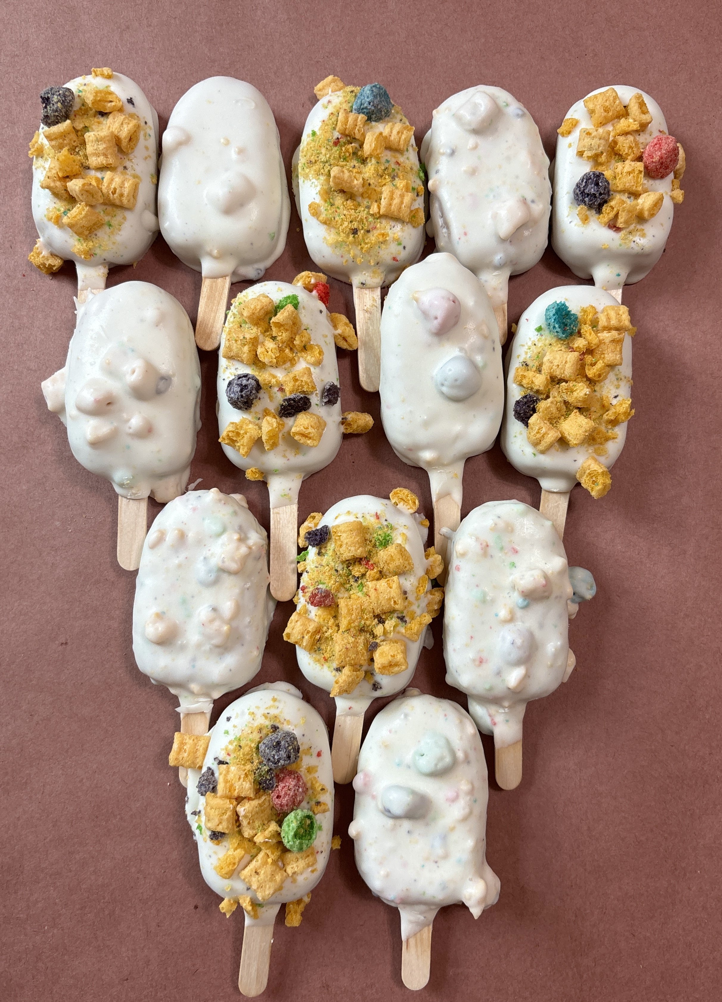 Captain Crunch Cakesicles. A delicious yellow cake with vanilla candy coating and captain crunch encased in candy coating or on top.