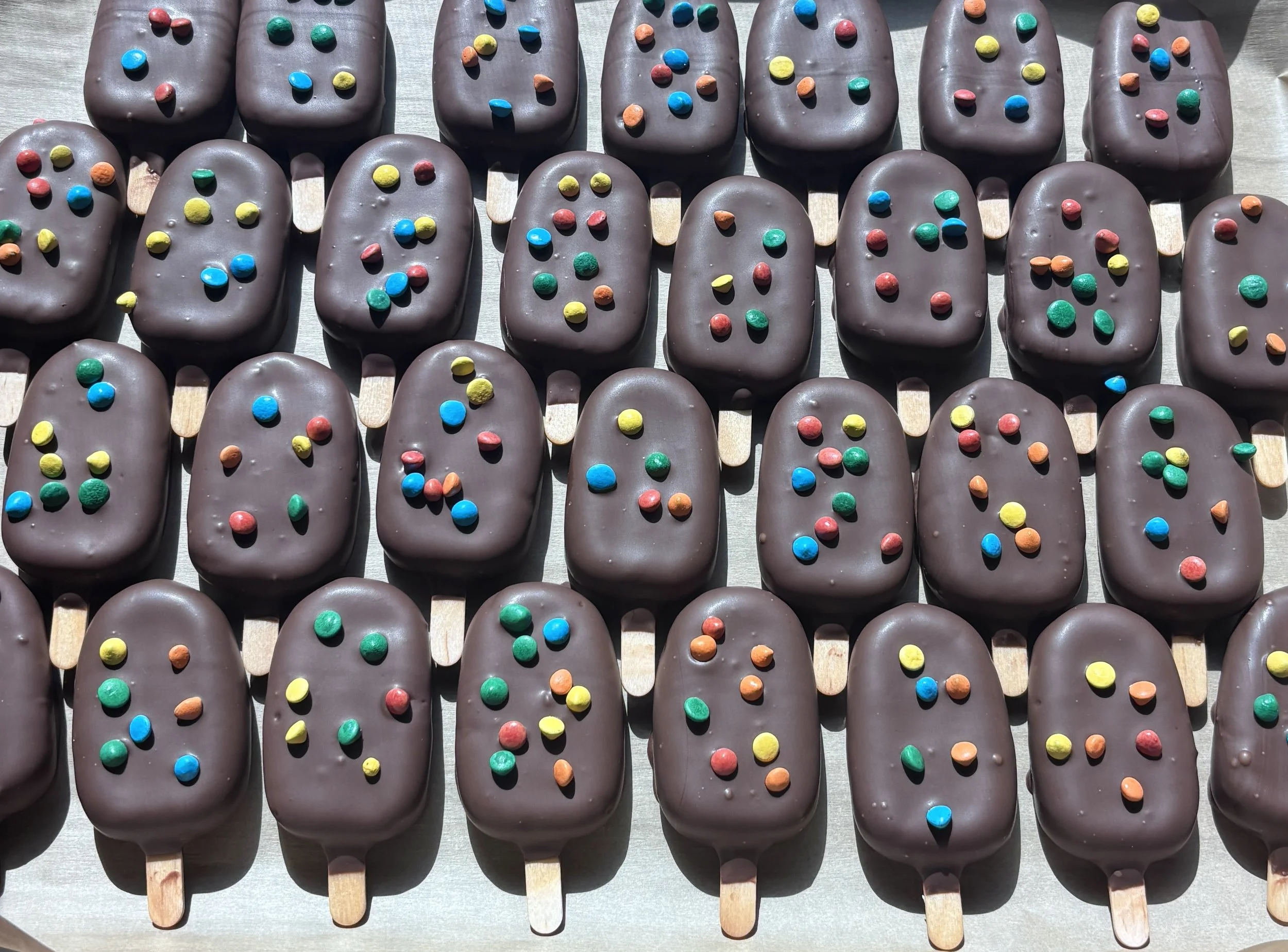A rich and classic chocolate cake dipped in a milk chocolate candy coating and topped with the iconic cosmic chips.