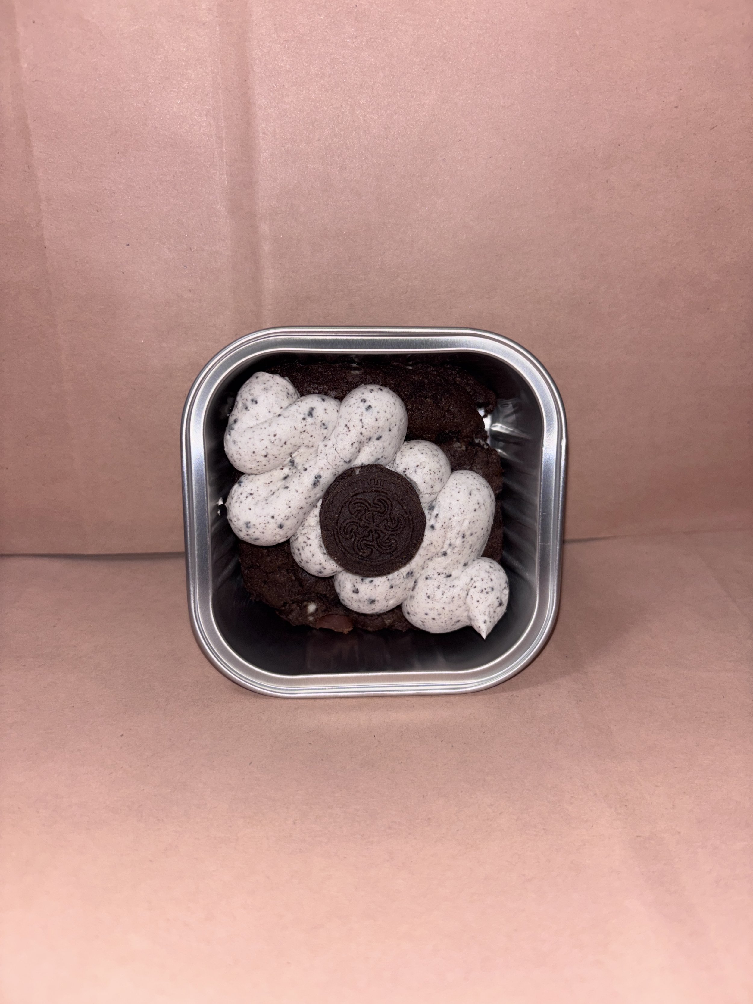 Our Double Chocolate Cookies&Cream Cookie Cake. It’s a Delicious chocolate cookie with chocolate chips and crushed up Oreos, with a Cookies&Cream buttercream topped with a mini Oreo 