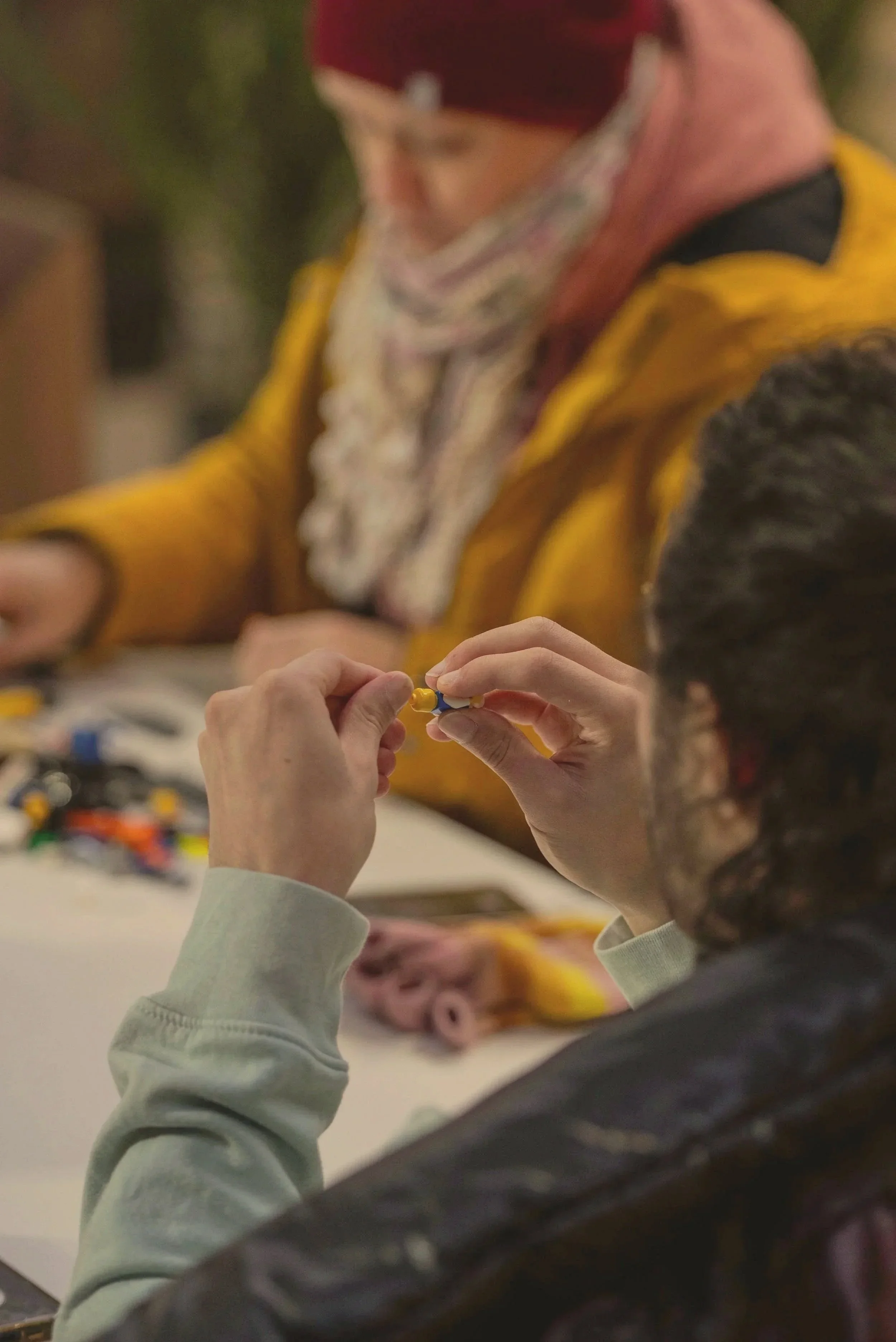 Participants creating small colorful objects during a hands-on arts workshop.