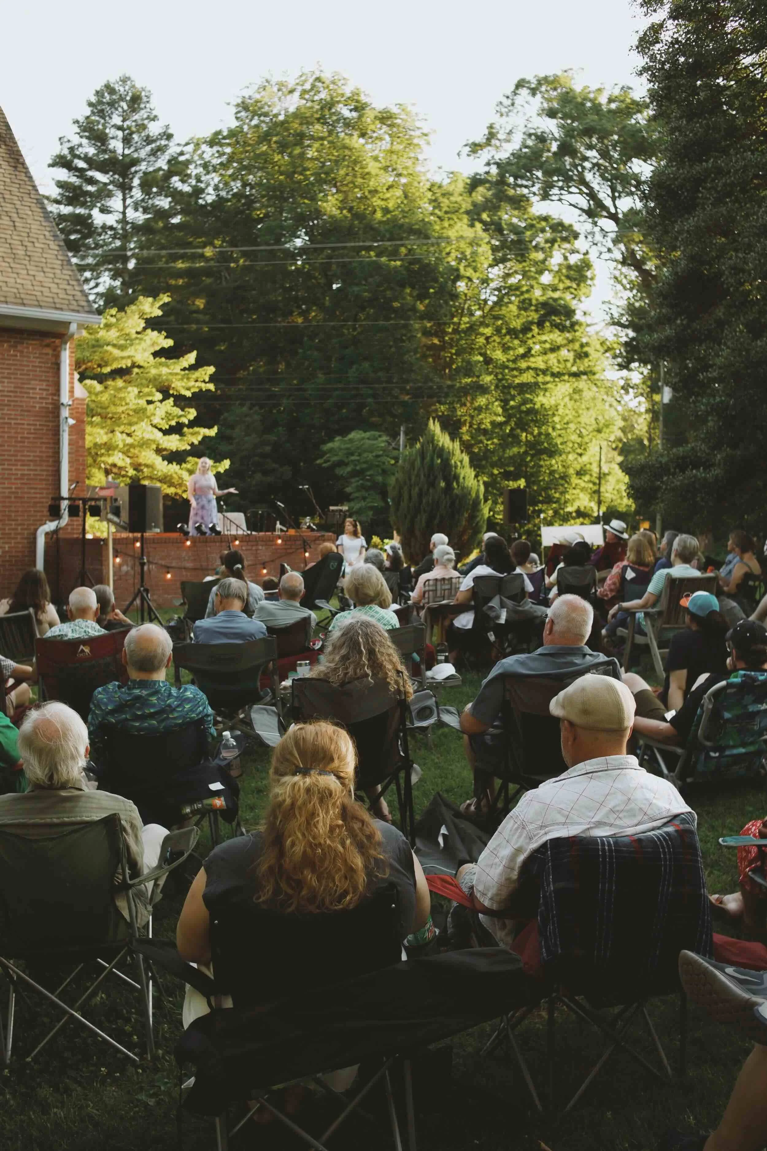 Audience gathered outdoors for a community arts performance.