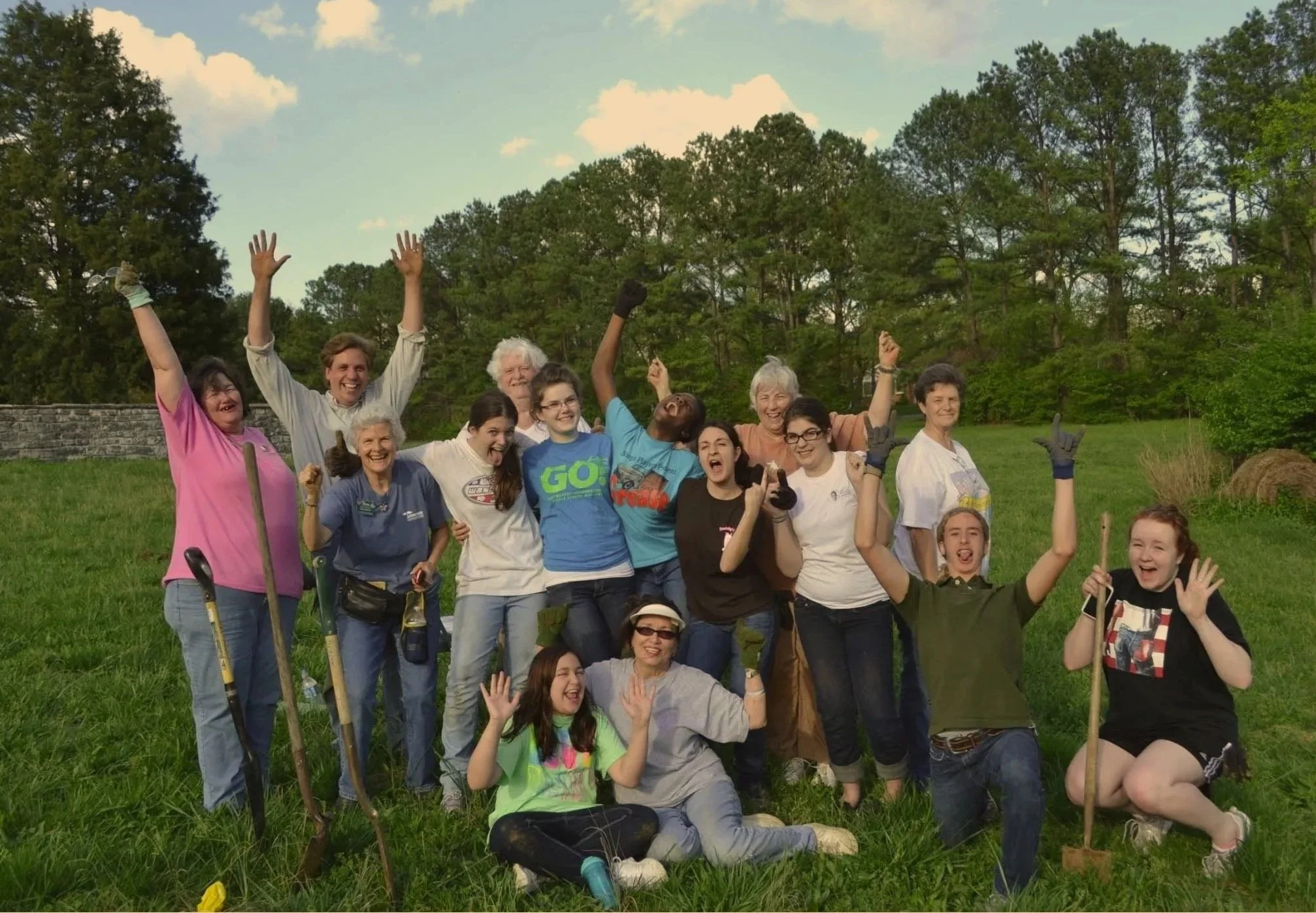 Group of people celebrating together outdoors after a community project.