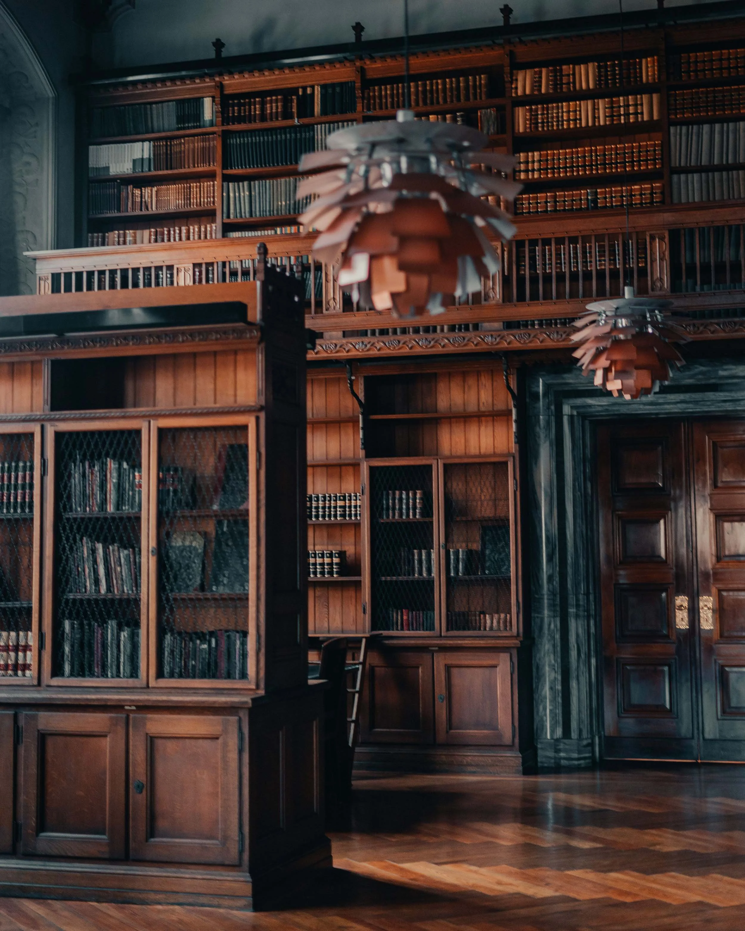 Historic library interior with floor-to-ceiling wooden bookshelves.