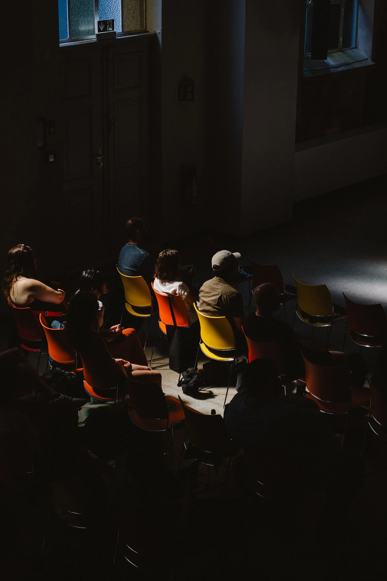 Audience seated in colorful chairs during a presentation or cultural program.