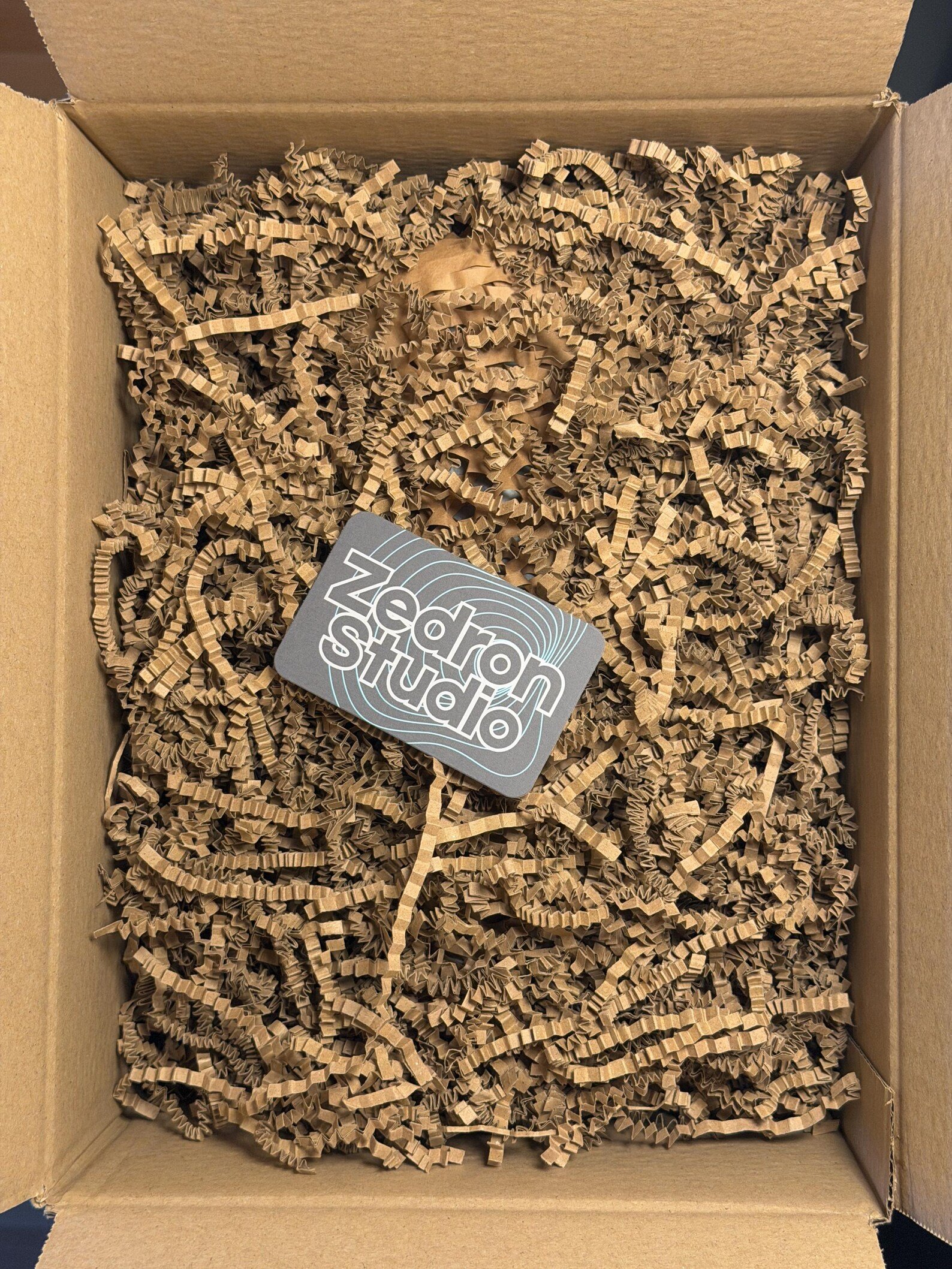 Brown cardboard box filled with crinkled paper packing material and a label that says 'Technology review' inside.