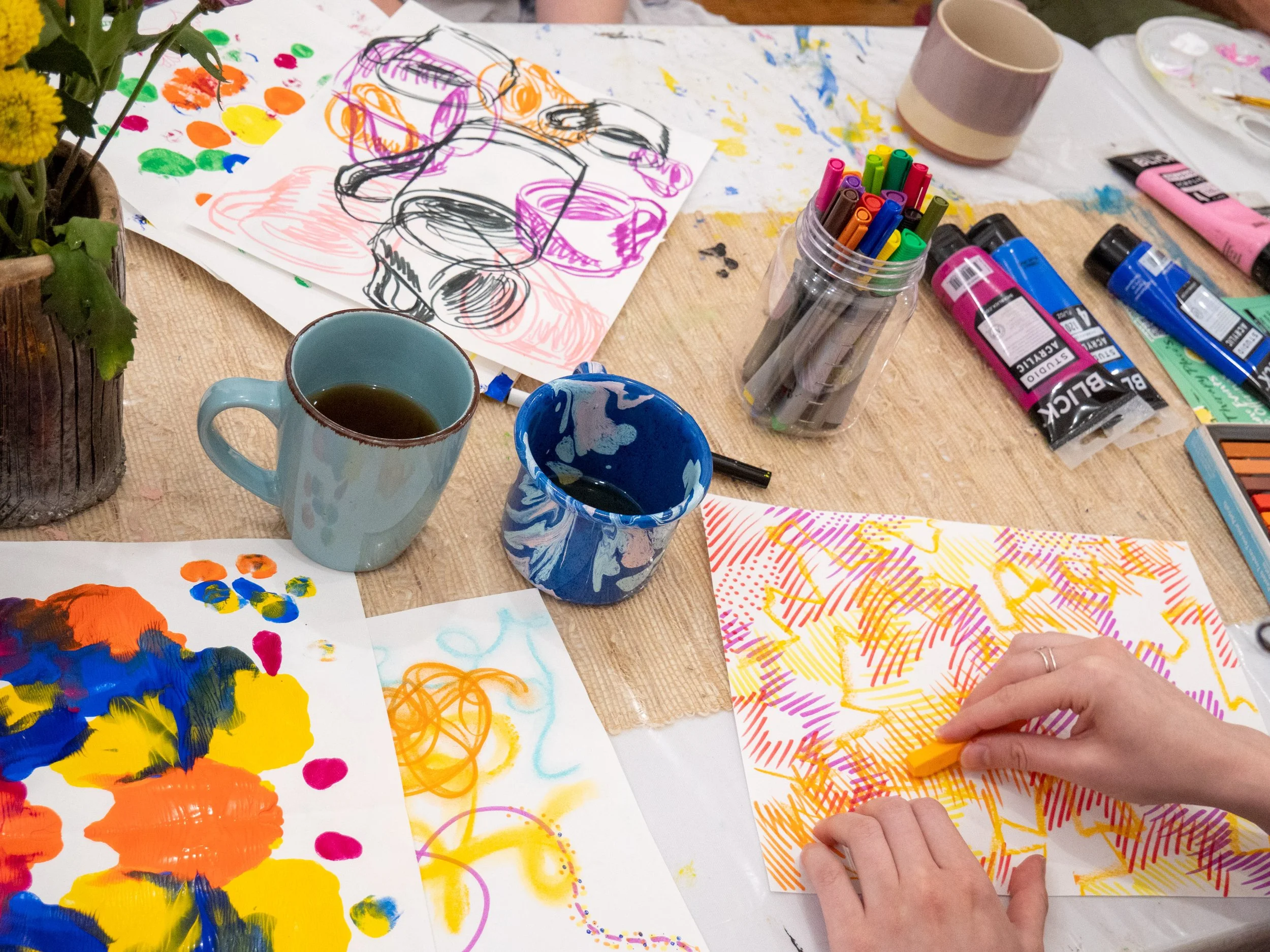 Adult participating in an expressive art therapy session using paint, markers, and mixed media in a Brooklyn therapy studio.