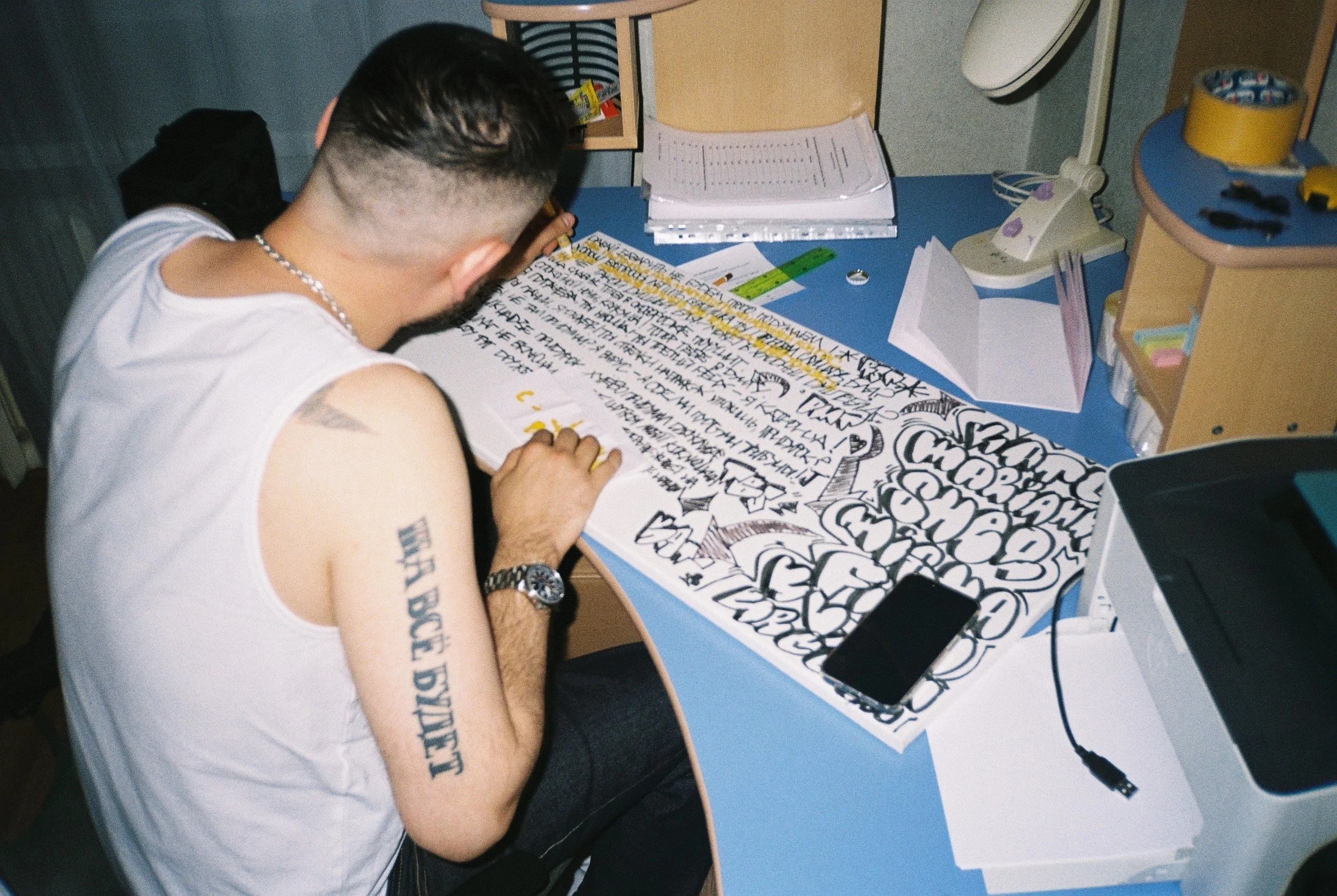 Adult man participating in an art therapy session using markers in the style of graffiti or street art.