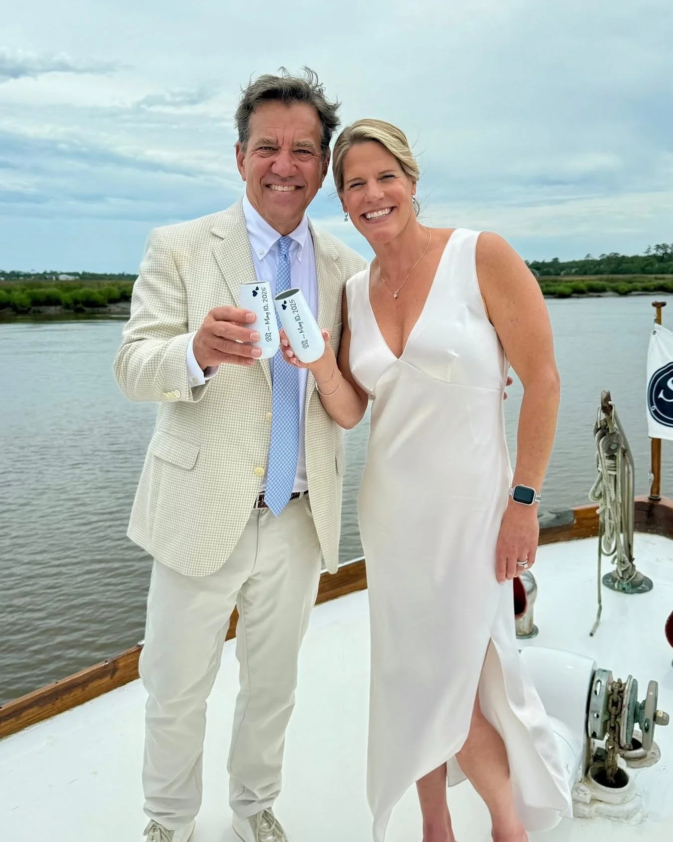 Couple in wedding attire posing on the deck of the String of Pearls