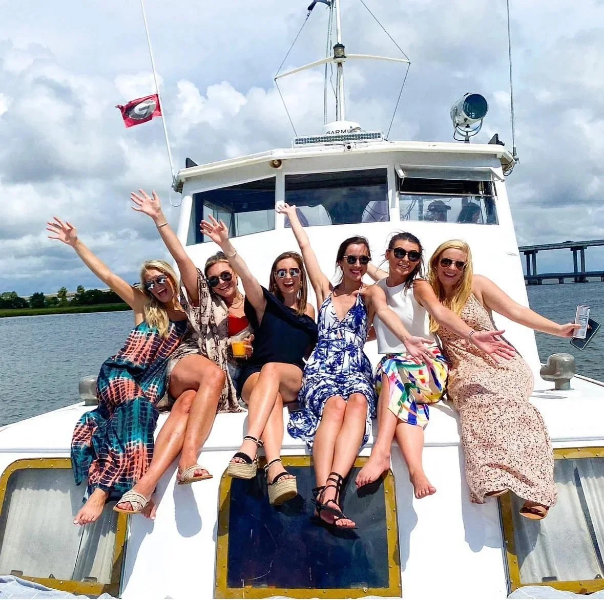 Bachelorette party waving from the bow of the String of Pearls yacht