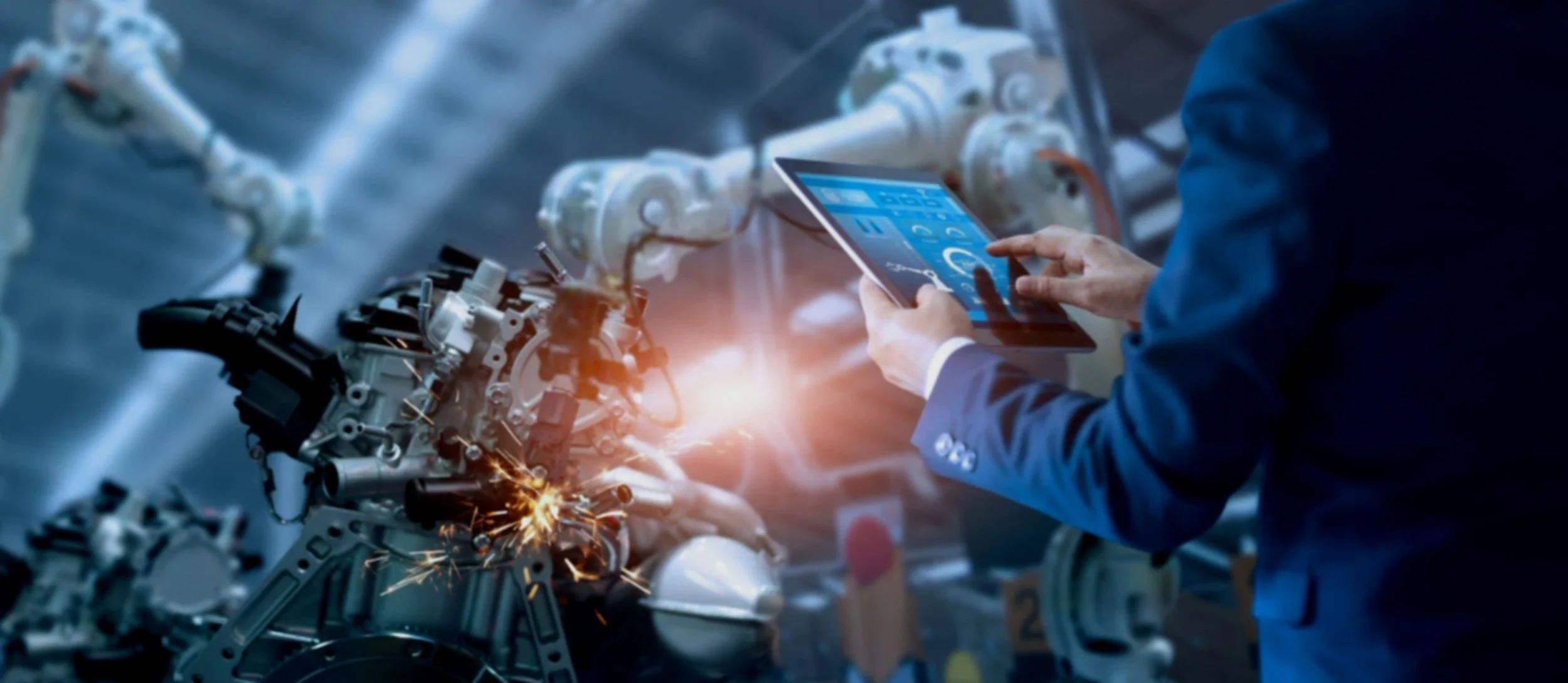 Engineer in a suit inspecting an industrial robotic arm with a tablet, sparks flying from welding or machining process.