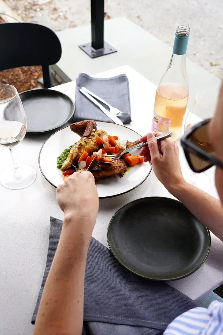 Guests sharing a half chicken dish at Cork Restaurant in Stowe, Vermont — a communal dining experience