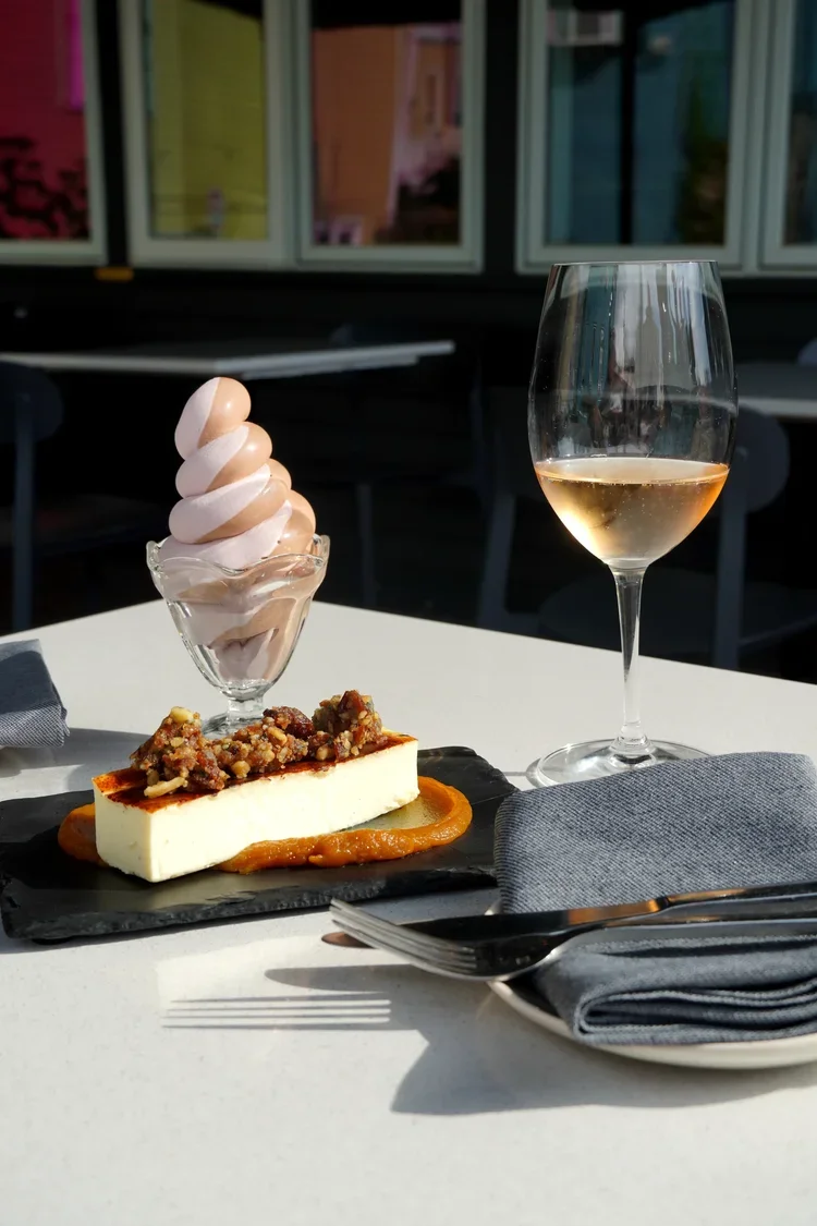 Seasonal dessert of fresh creemess and cheesecake with natural wine at Cork Restaurant in Stowe, Vermont — chef-driven tasting menu
