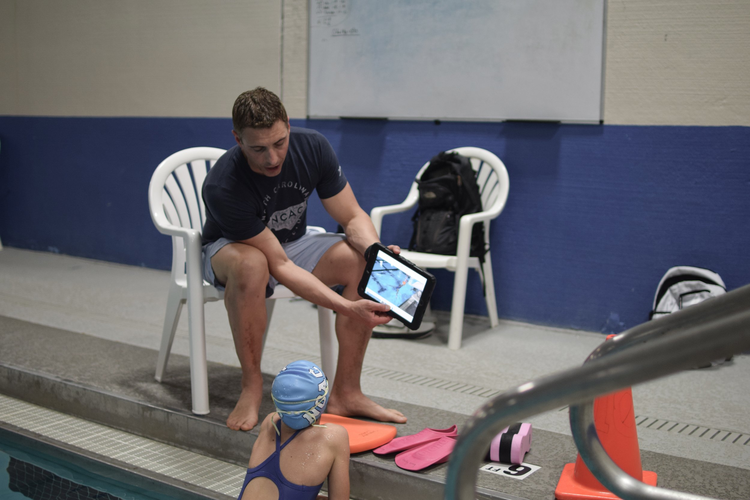Coach Sean instructs swimmer using instant corrective feedback via video on a tablet