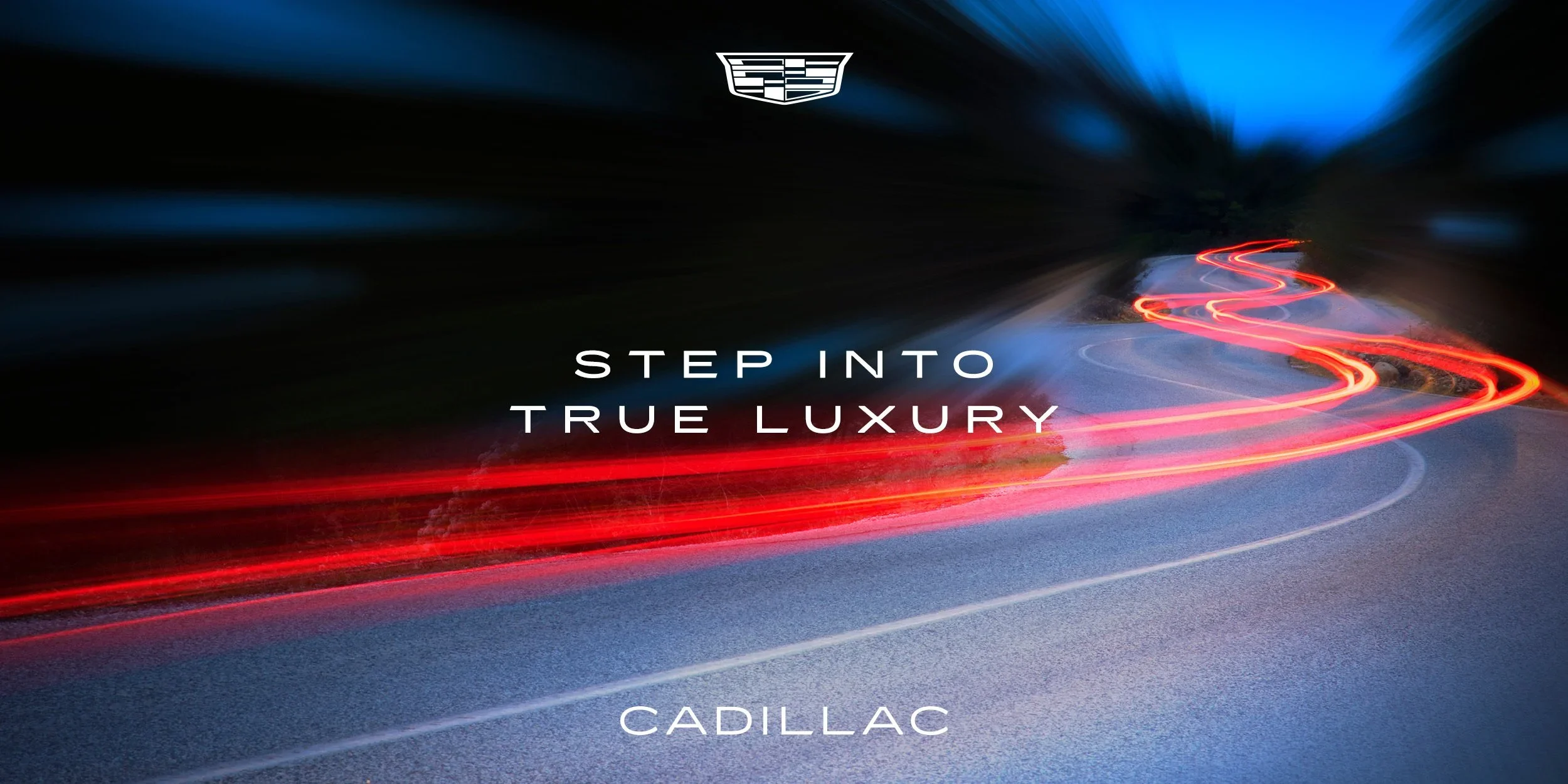 A blurred nighttime photo of a winding road with red and white light trails from moving vehicles, with the Cadillac logo and the text 'Step into true luxury' overlayed.