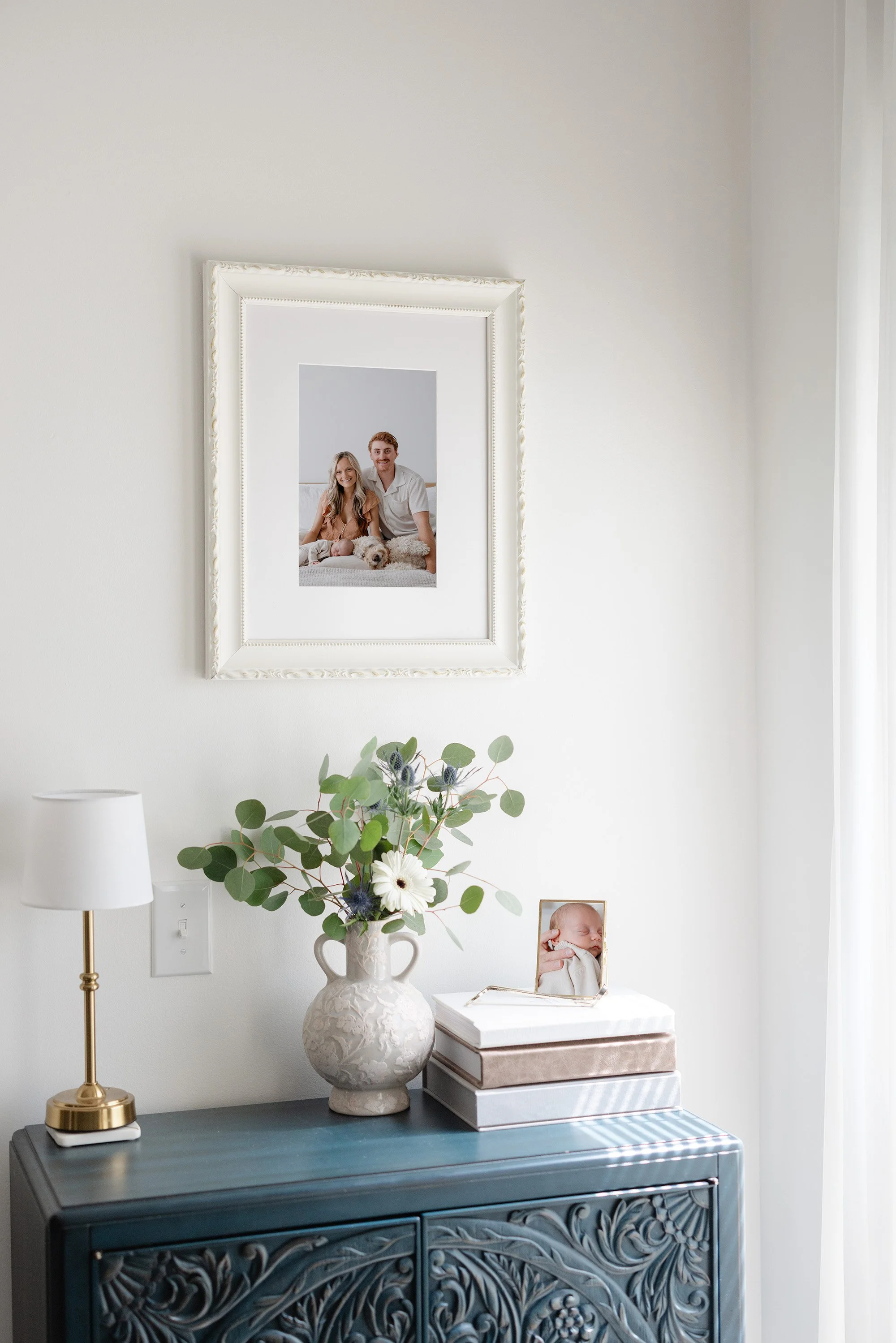 An heirloom custom-framed family picture hung on a wall by Sari Risbey Photography in Winnipeg.