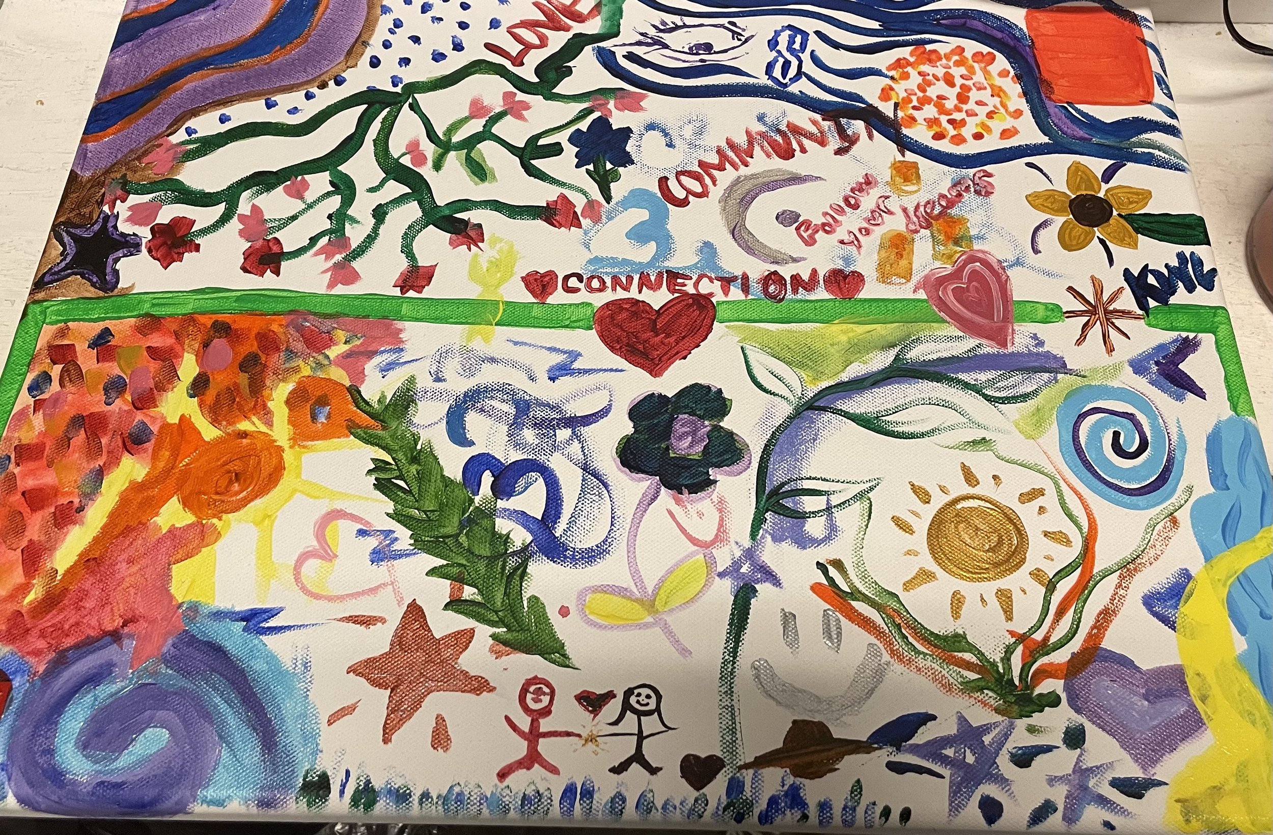 Colorful abstract painting with various shapes and words such as 'connection,' 'community,' and 'you.' There are flower-like designs, stick figures, and lively brushstrokes.