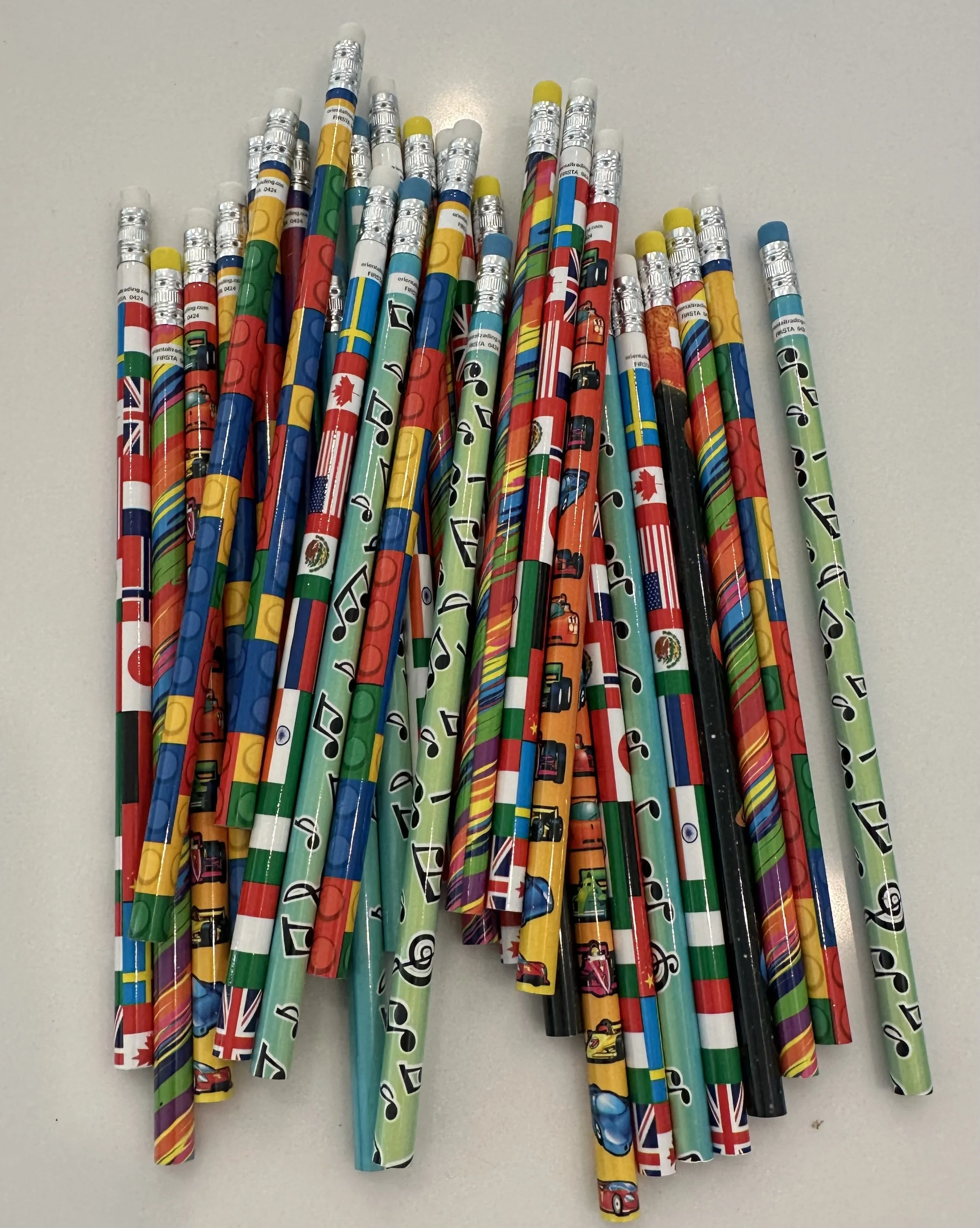 Colorful party blowers with international flag patterns, arranged on a white surface.