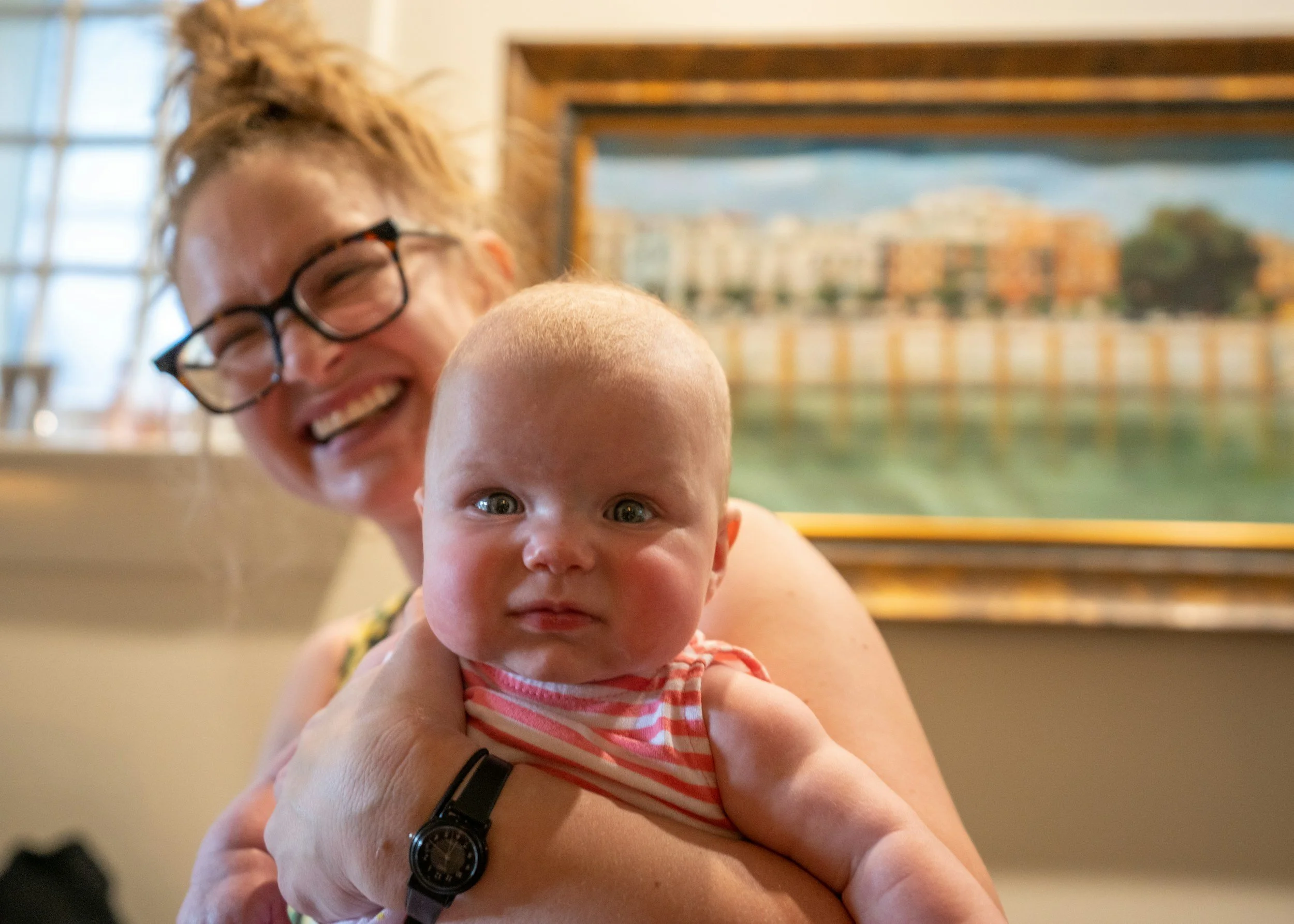 New mom with a messy bun holding a baby. perinatal therapy.