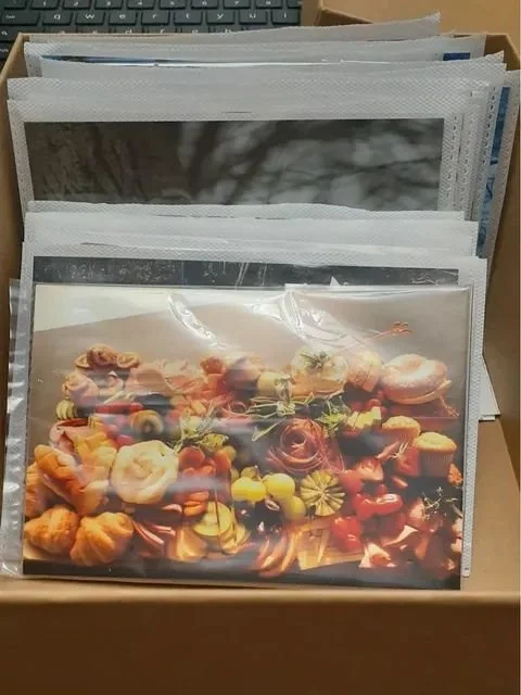 A collection of unframed prints in plastic sleeves