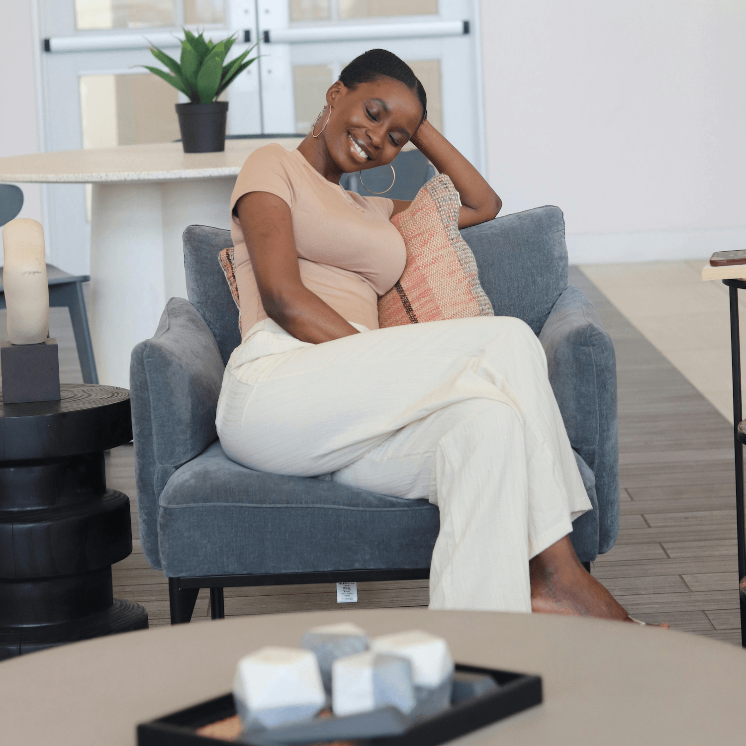 woman smiling on couch thinking of how the digital product writing guide will help her create her first digital product