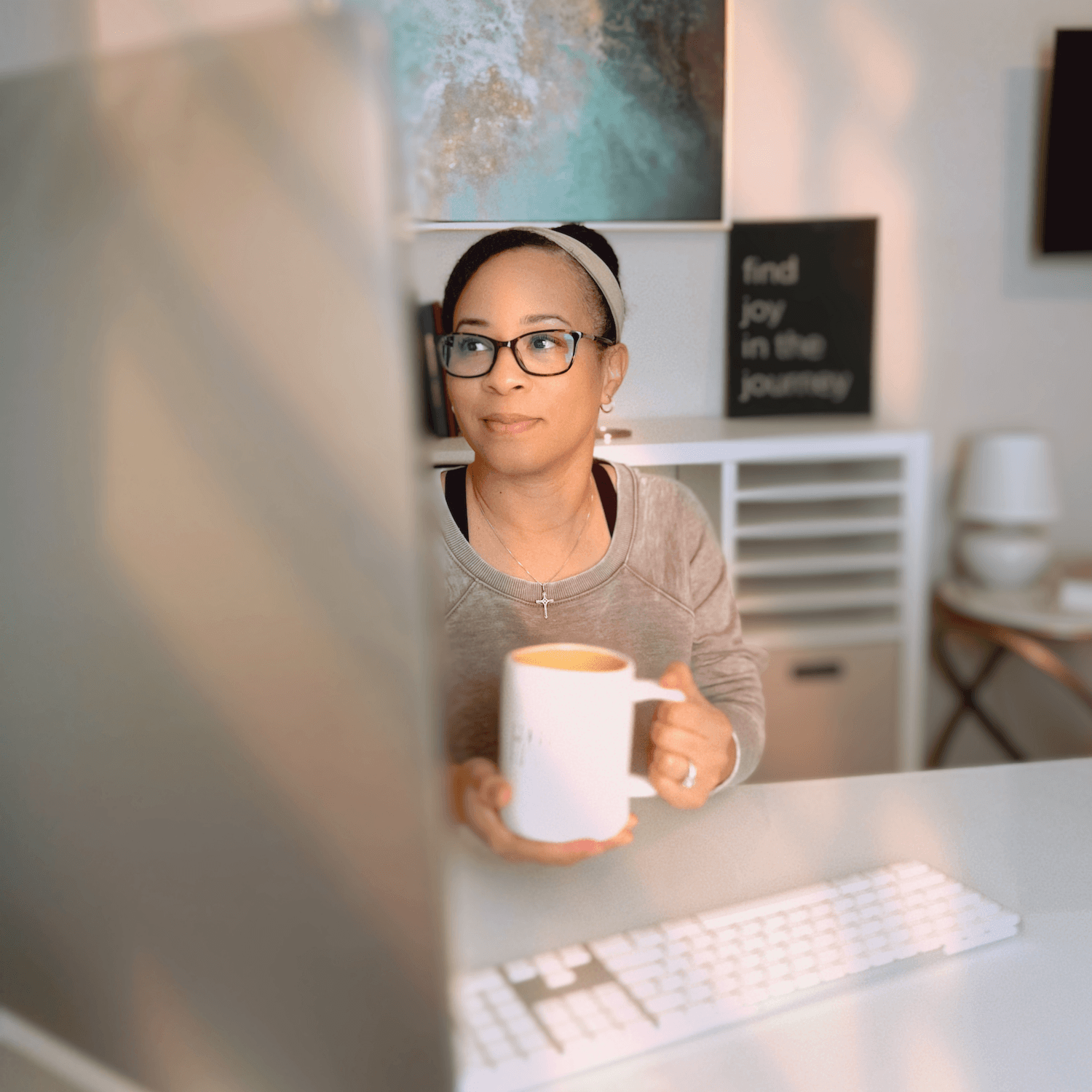 meet the creator sitting at computer working in office holding cup of tea