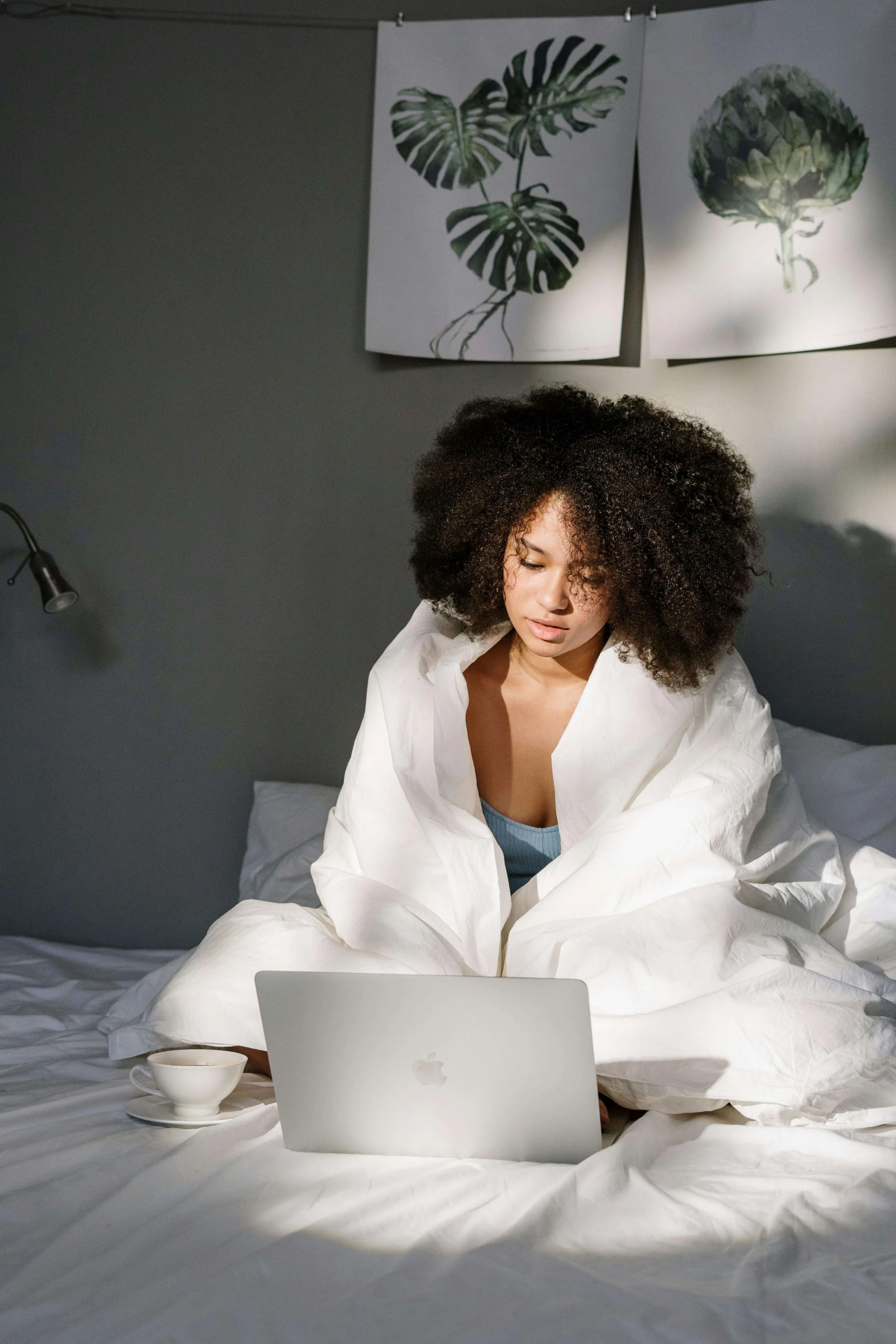 Woman creating her first digital product on laptop from her bed