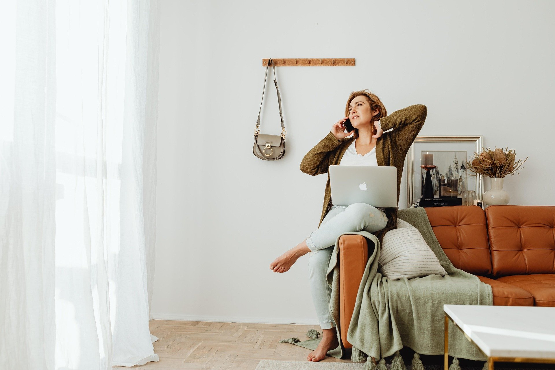 Woman building something of her own from home on laptop from couch