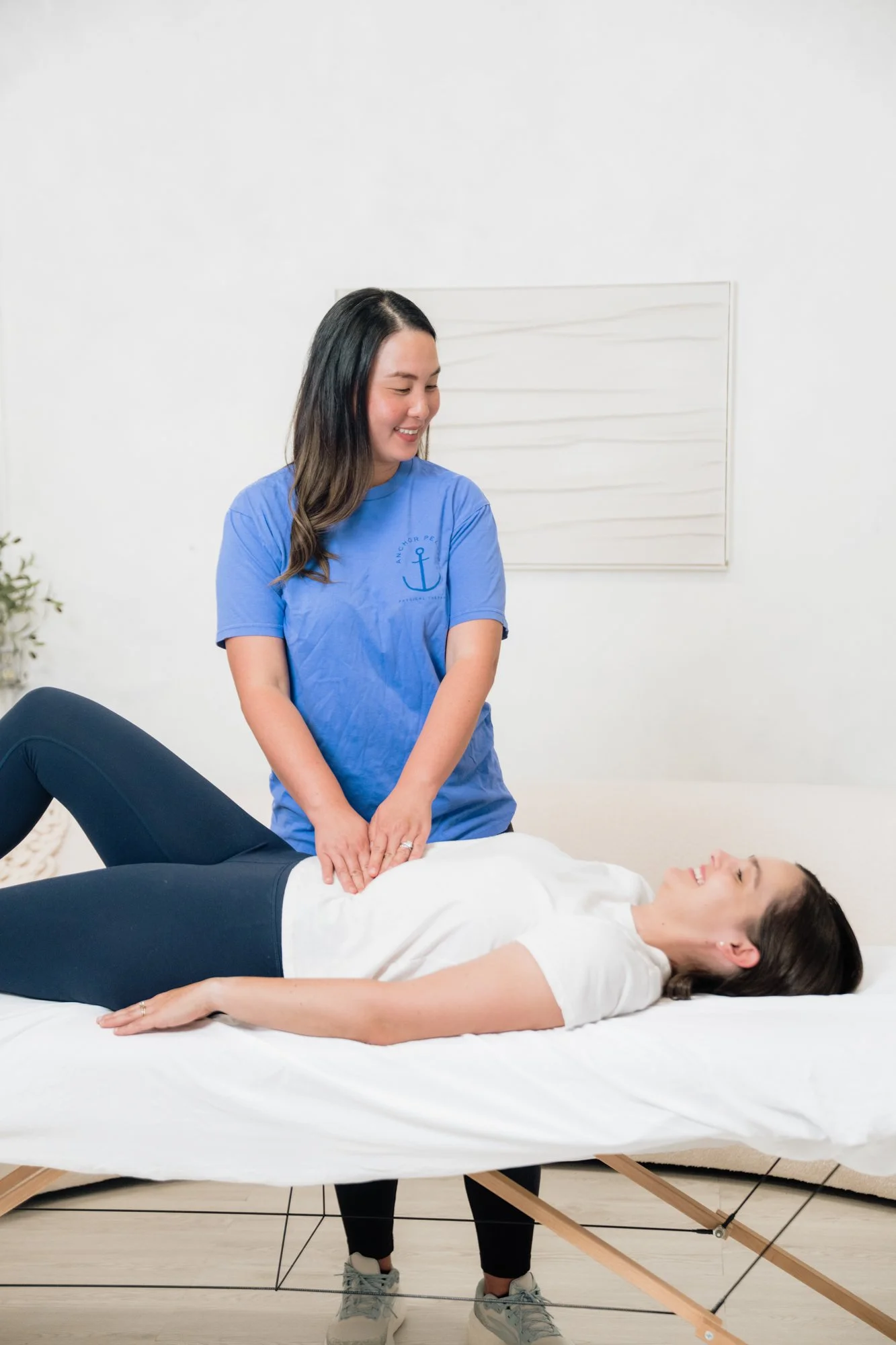 a pelvic floor therapist palpating the abdomen of a patient