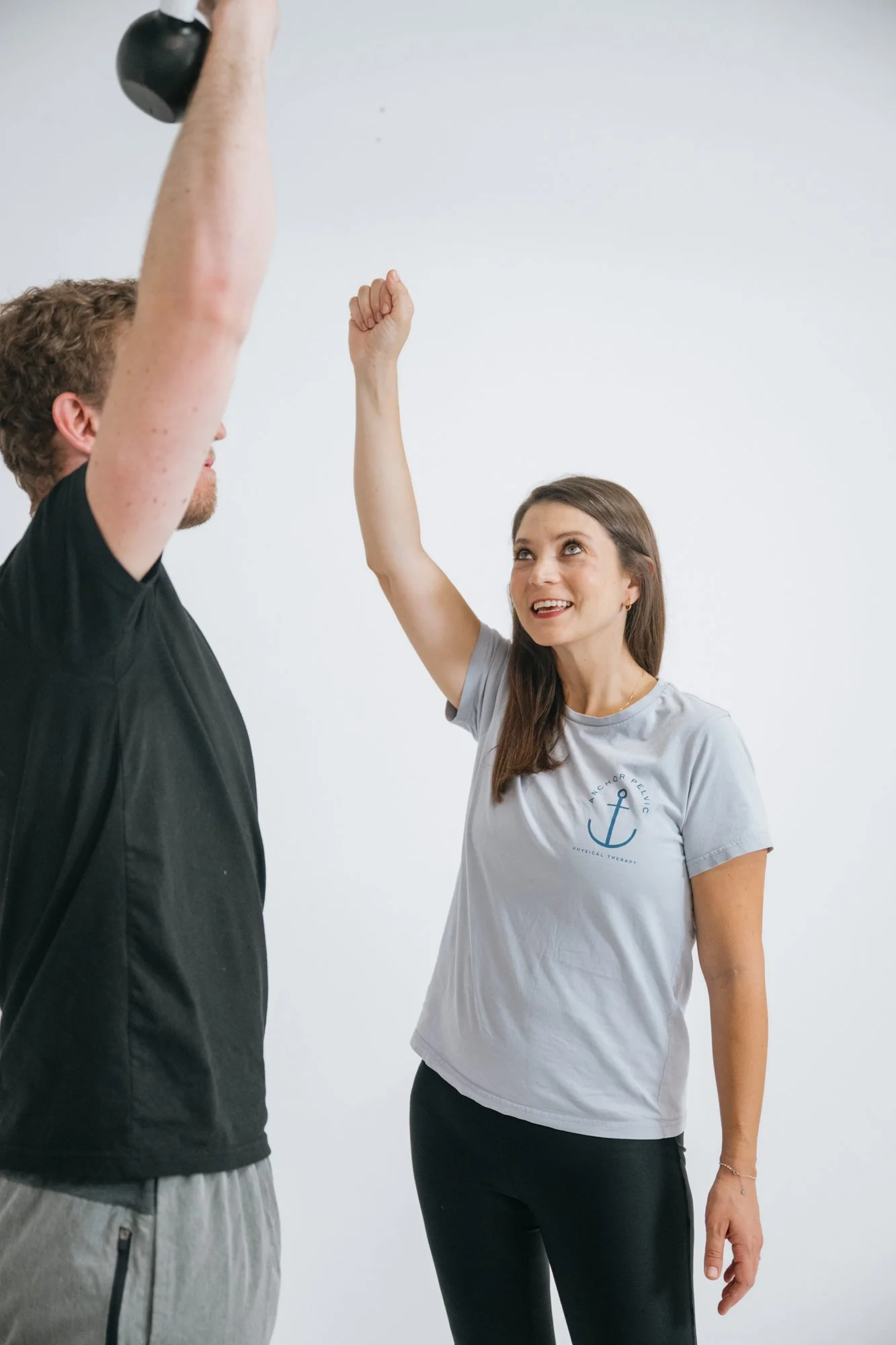 pelvic therapist working on overhead mobility in a session with a male patient