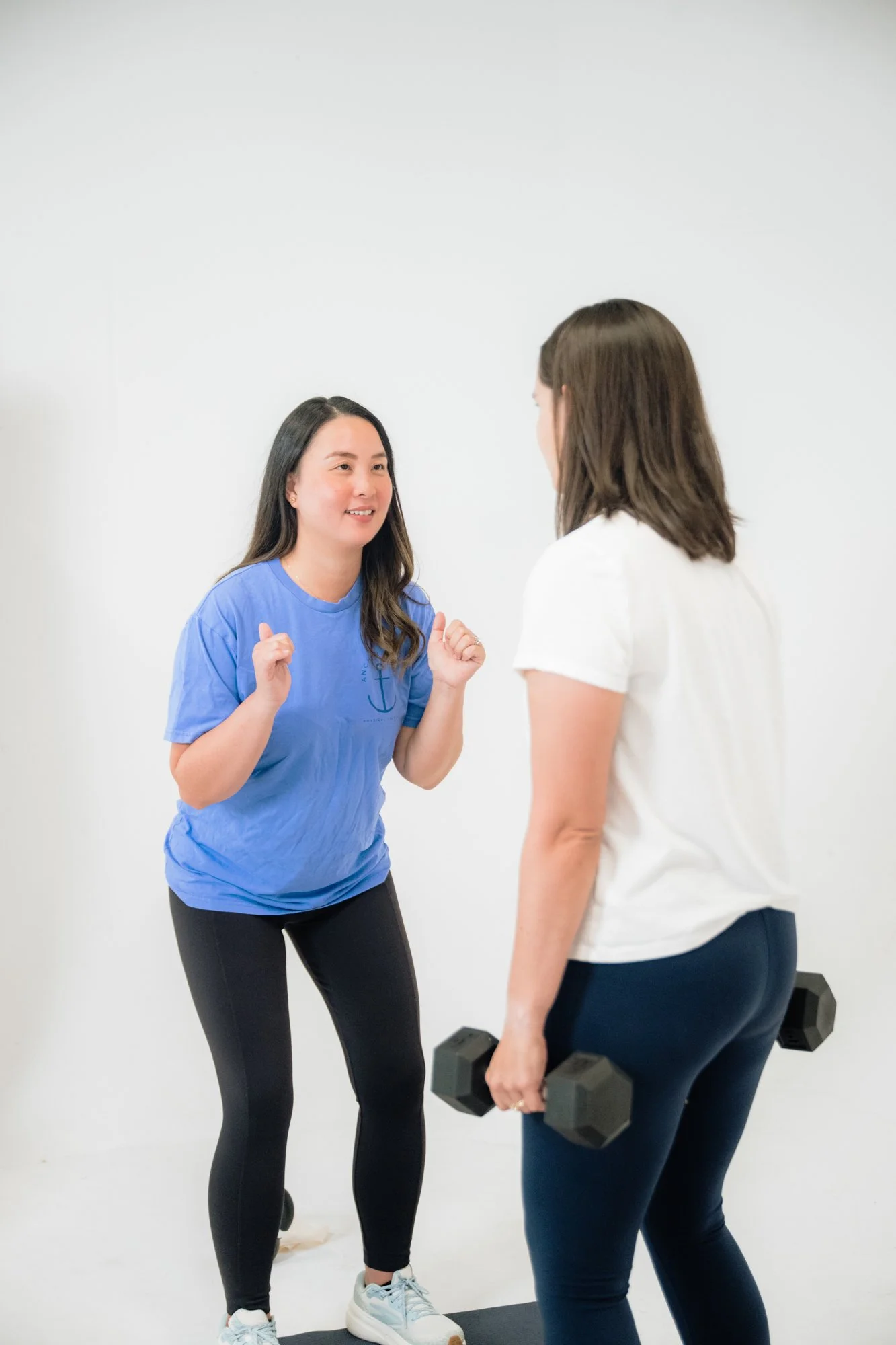 A pelvic floor physical therapist doing squats with a patient who has pelvic organ prolapse.
