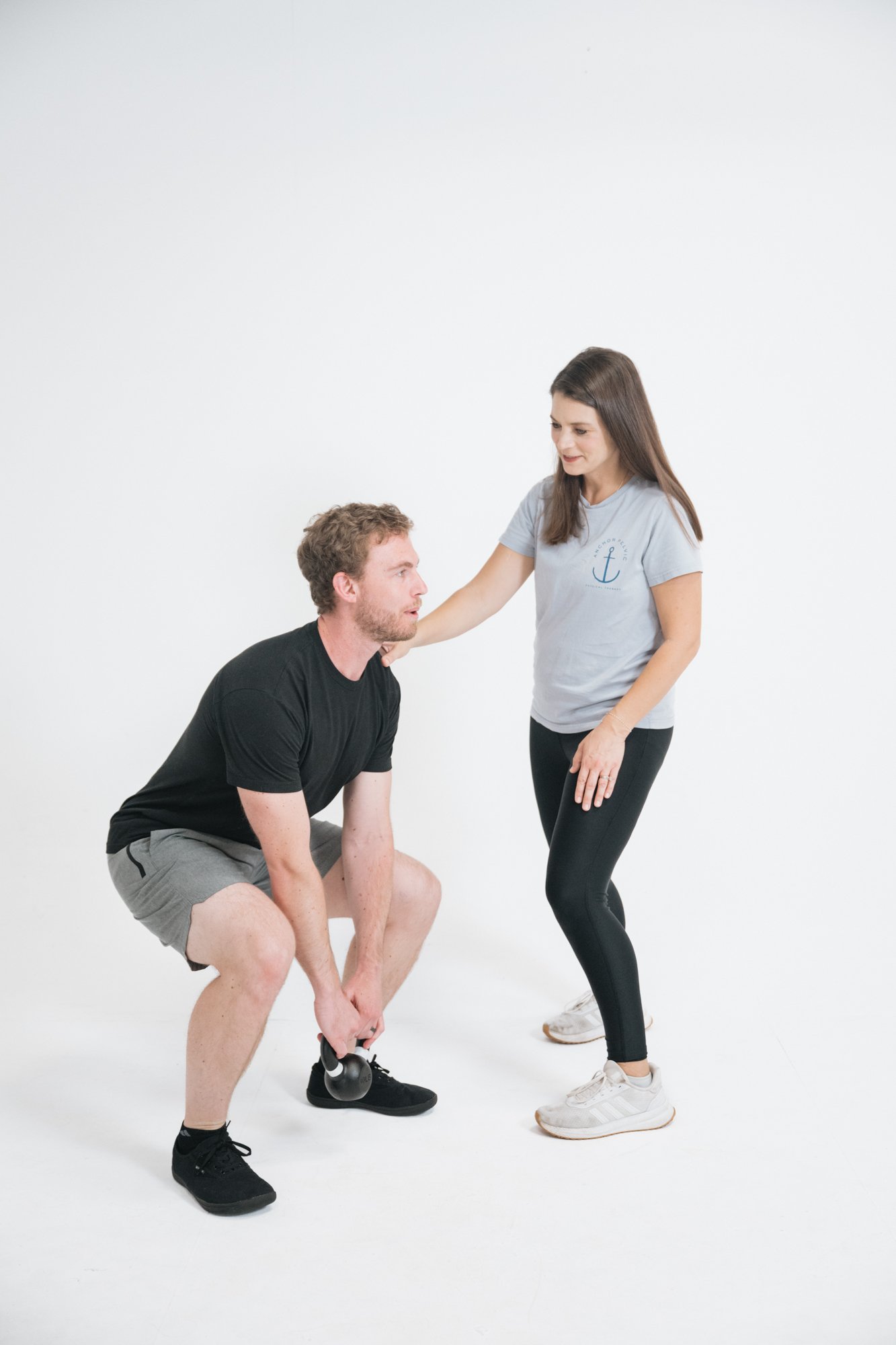 a male patient doing a squat with a pelvic floor therapist