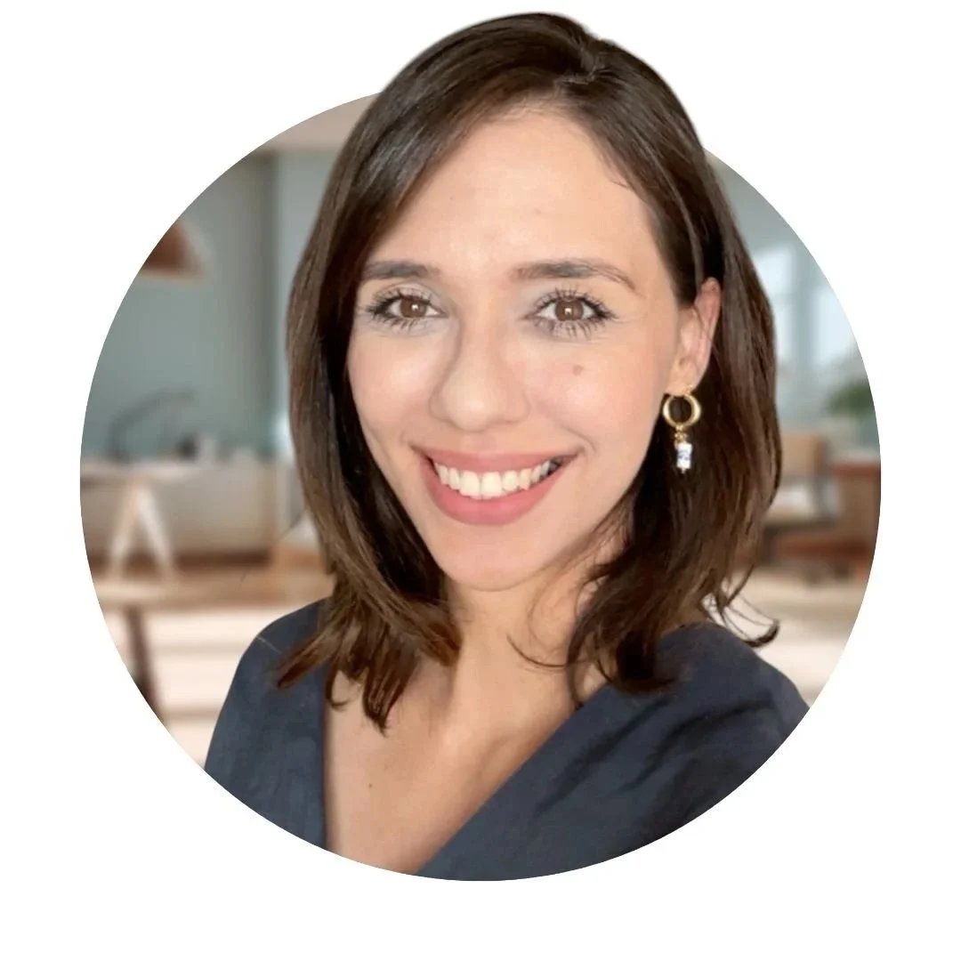 Mulher de cabelo castanho, sorriso, brincos dourados, fundo de casa moderna
