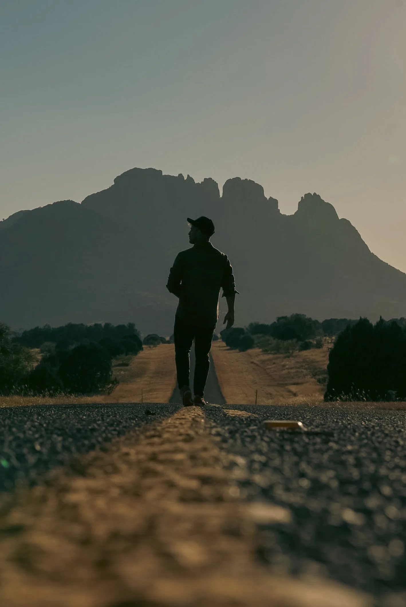Silhouette taken in October of 2024 of Carlos walking down Texas Scenic Route 166 with Sawtooth Mountain in the background, resembling discovery, inner-peace and new beginnings.
