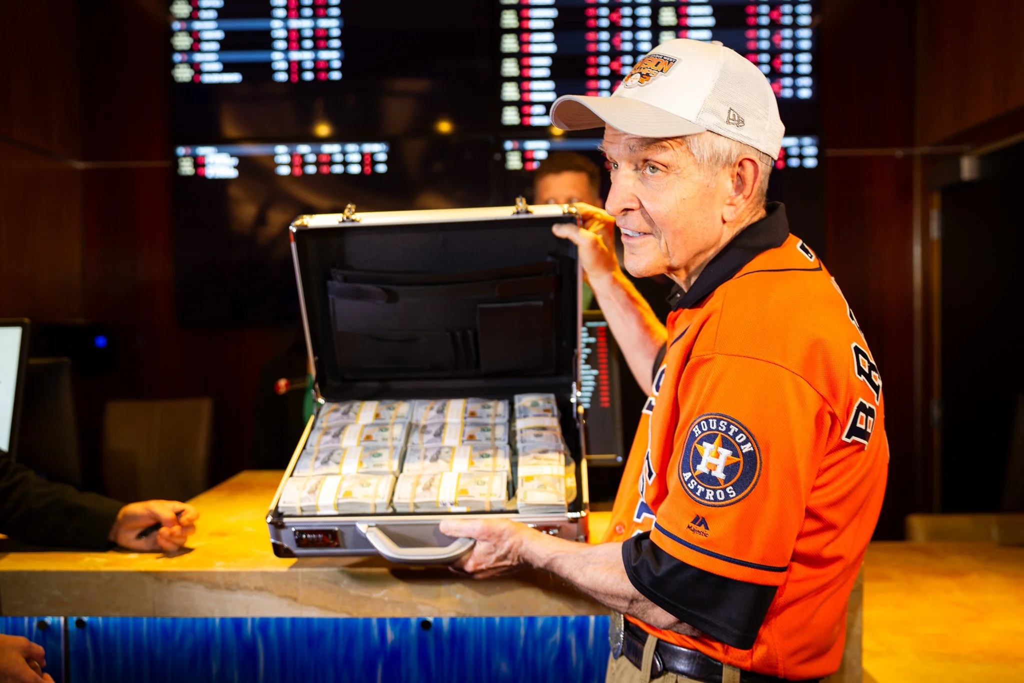 Mattress Mack of Gallery Furniture holding a briefcase filled with stacks of bundled U.S. hundred-dollar bills during one of his bets placed on the Houston Astros, to hedge furniture purchases.