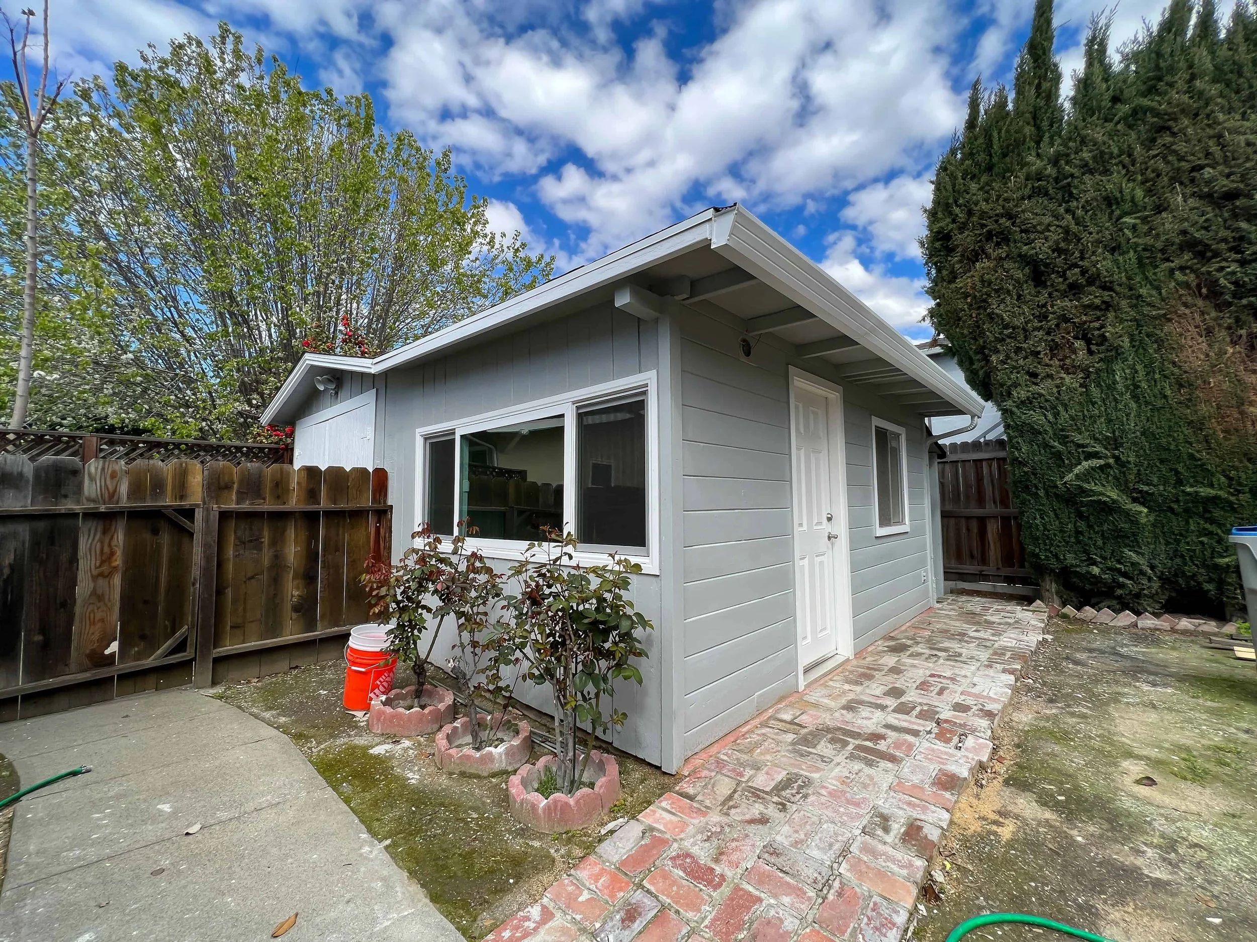 Downtown San Jose ADU from a converted garage. The main entrance sits in the backyard and is painted gray with white trim.