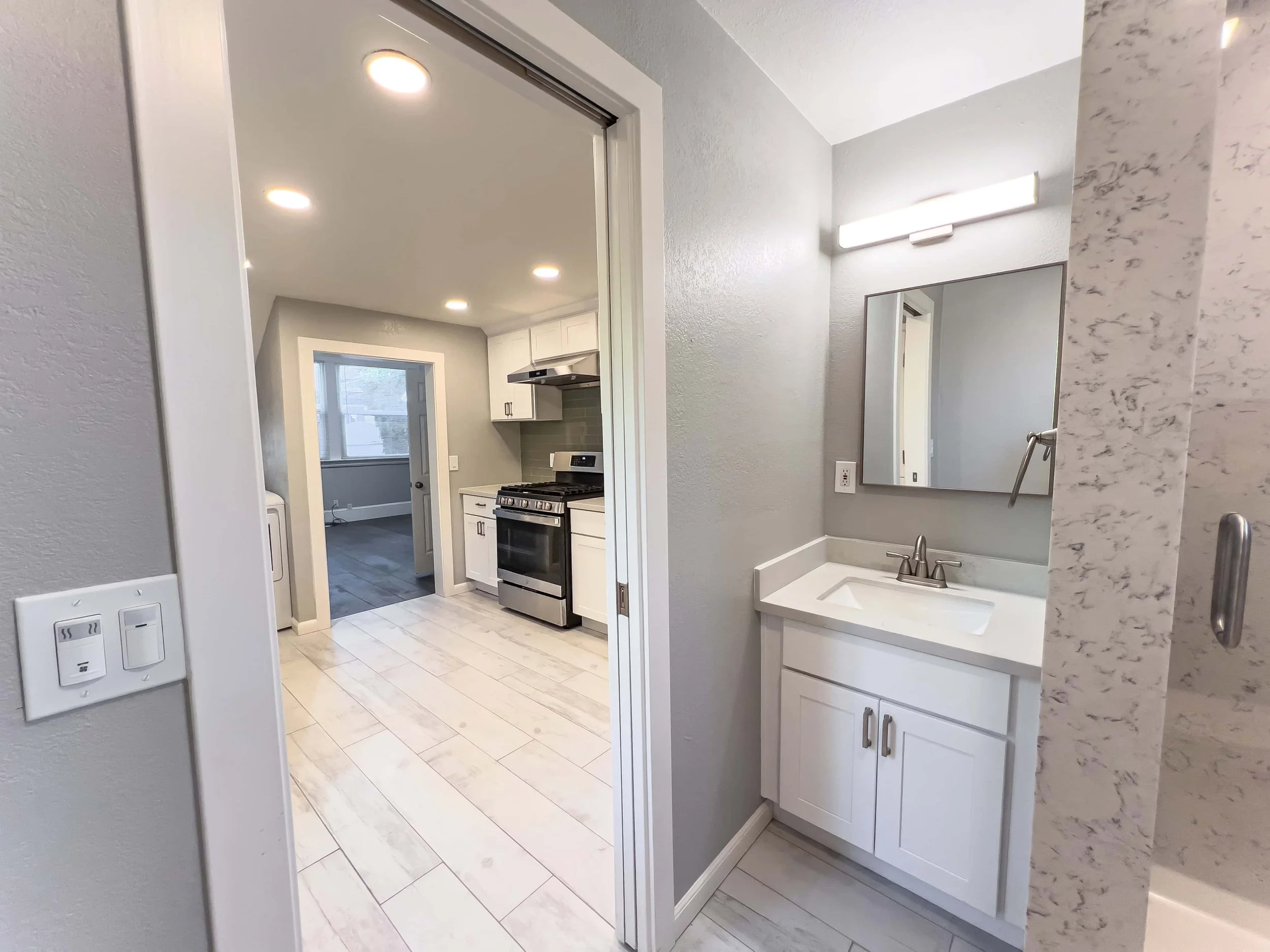 View of a small ADU bathroom and bright kitchen.